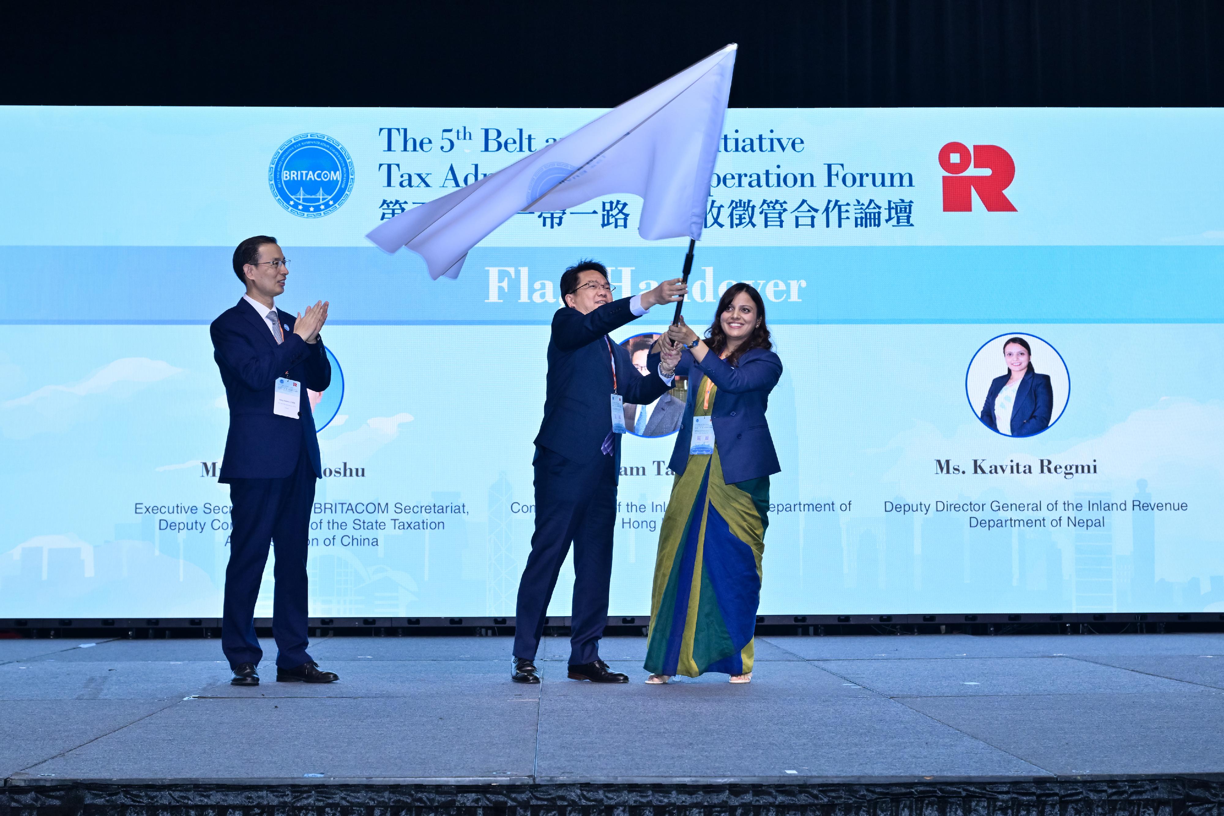 The 5th Belt and Road Initiative Tax Administration Cooperation Forum (BRITACOF) concluded successfully today (September 26). Photo shows the Commissioner of Inland Revenue and the Chairman of the 5th BRITACOF, Mr Tam Tai-pang (centre), handing over the flag of the BRITACOF to the Deputy Director General of the Inland Revenue Department of Nepal, Ms Kavita Regmi (right), who represents the host of the 6th BRITACOF, during the flag handover ceremony held at the closing ceremony.
