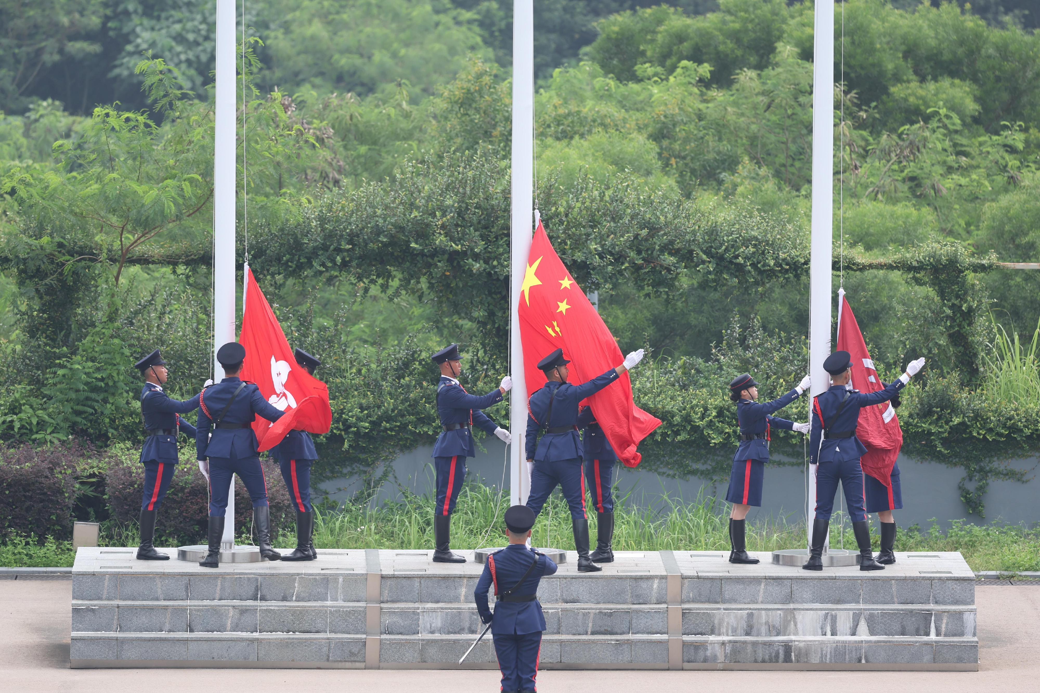 The Secretary for Security, Mr Tang Ping-keung, reviewed the Fire and Ambulance Services Teen Connect (FAST Connect) Rally in Celebration of the 75th Anniversary of the Founding of the People's Republic of China held by the Fire Services Department (FSD) today (September 28). Photo shows Guards of Honour of FAST Connect and that of the FSD jointly conducting a flag raising ceremony.