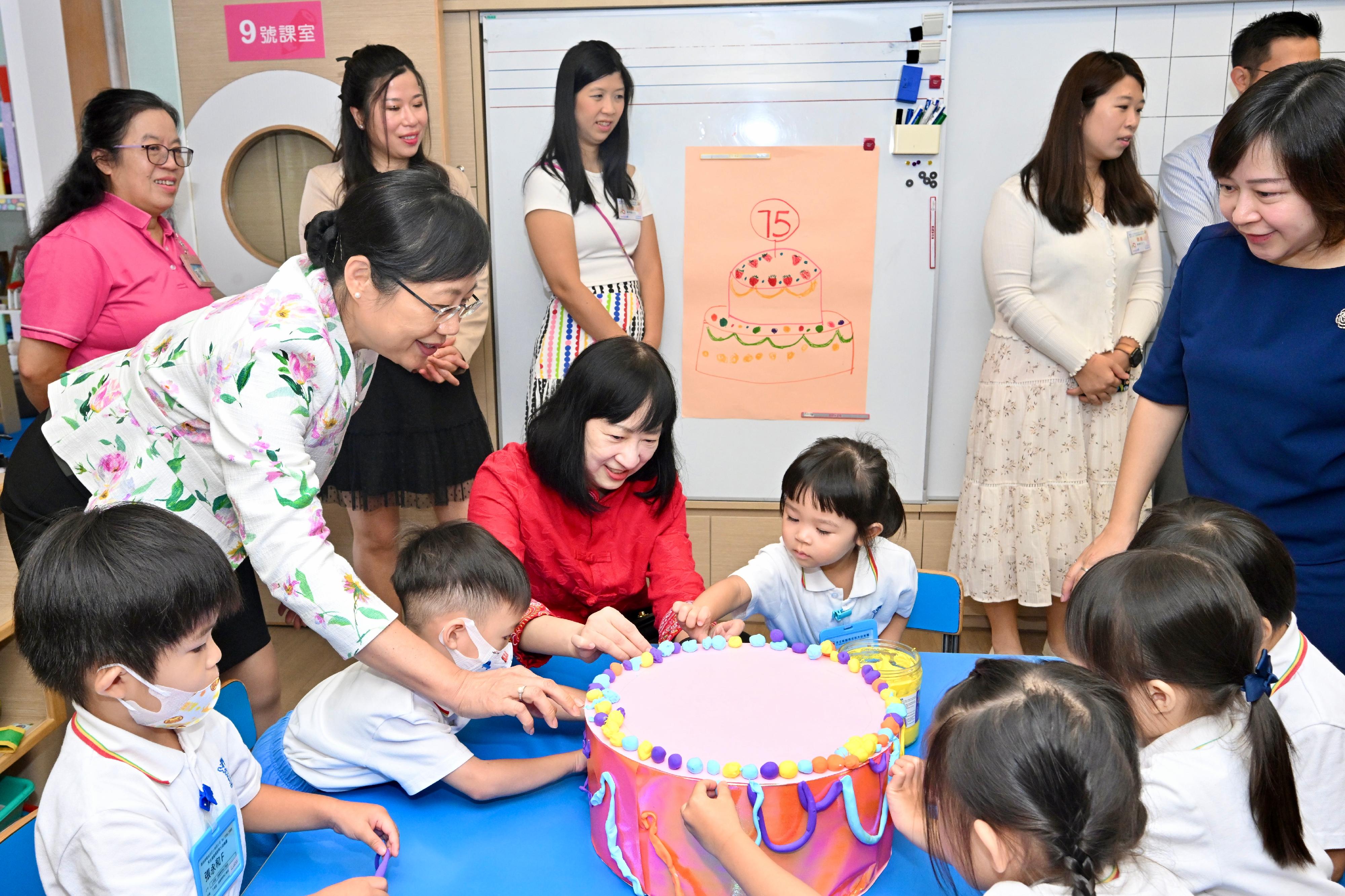 为庆祝中华人民共和国成立75周年，教育局鼓励全港中小学和幼稚园按学校的实际情况，今日（九月三十日）上课前举行升国旗仪式及奏唱国歌，从中增强学生的国家观念，弘扬爱国精神和民族自豪感。图示教育局常任秘书长李美嫦（左二）今早在天主教圣玛加利大幼稚园与学生交流。
