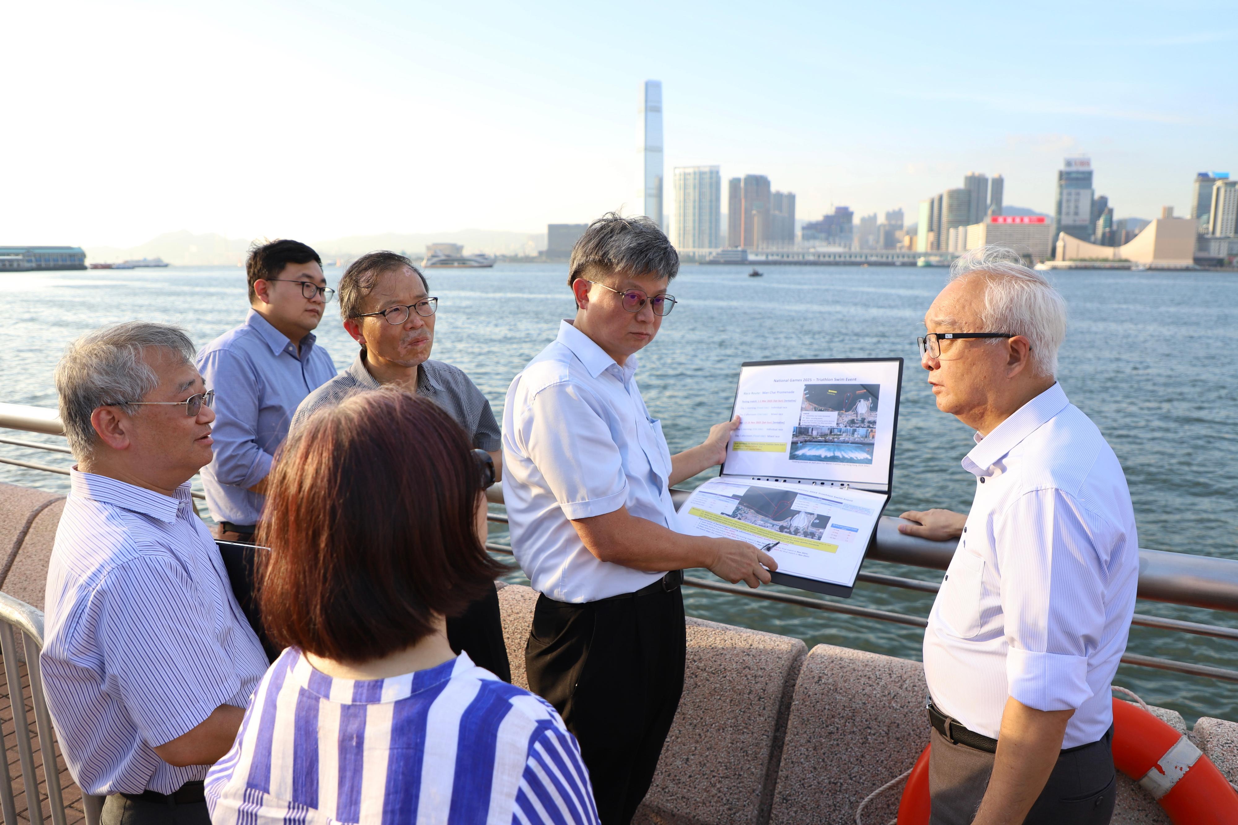 环境及生态局局长谢展寰（右一）今日（九月三十日）到土瓜湾、深水埗及湾仔海滨一带，了解改善维港近岸水质及气味工作的进展。图示谢展寰在湾仔海滨了解该区各项改善水质措施，为二○二五年第十五届全国运动会的三项铁人赛作准备。