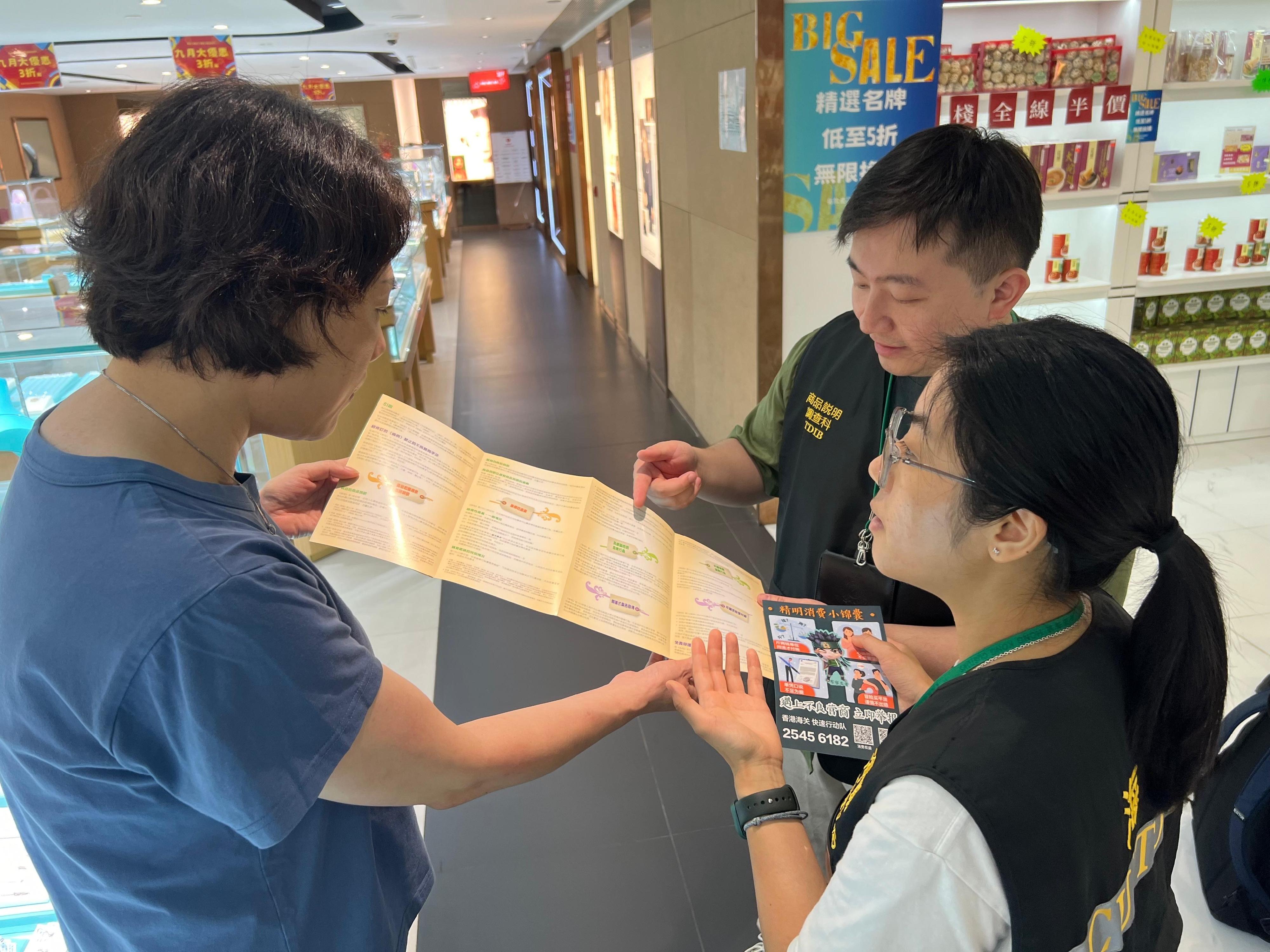 香港海关于内地国庆黄金周期间加强巡查全港各区的购物热点，提醒商户须要遵守《商品说明条例》的规定，以保障本地消费者和访港旅客的权益。图示海关人员在尖沙咀派发宣传单张。