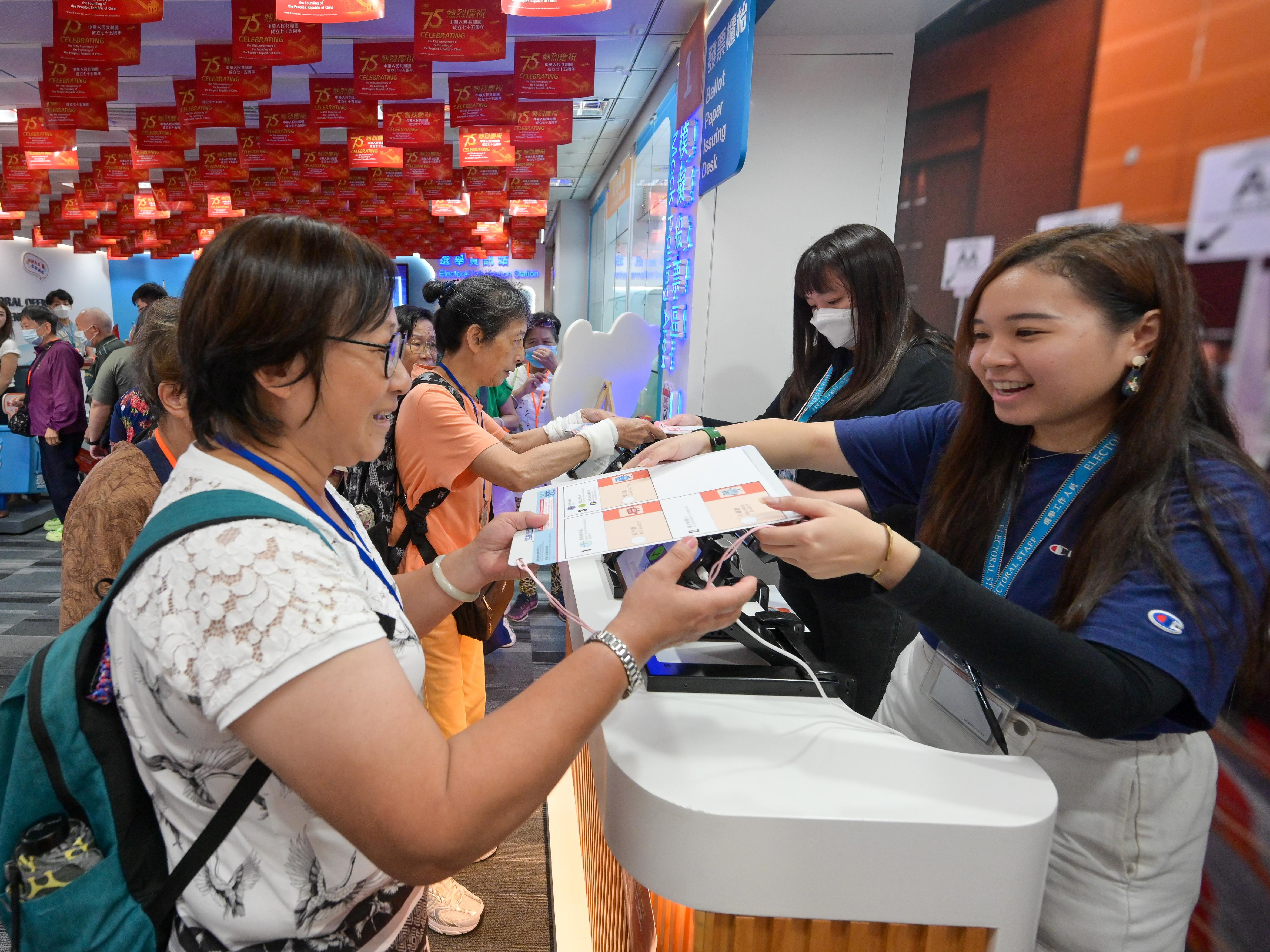 To celebrate the 75th anniversary of the founding of the People's Republic of China, the Electoral Information Centre of the Registration and Electoral Office is holding National Day Open Days for three consecutive days from today (September 30). Photo shows visitors participating in a mock polling activity to experience the voting process.