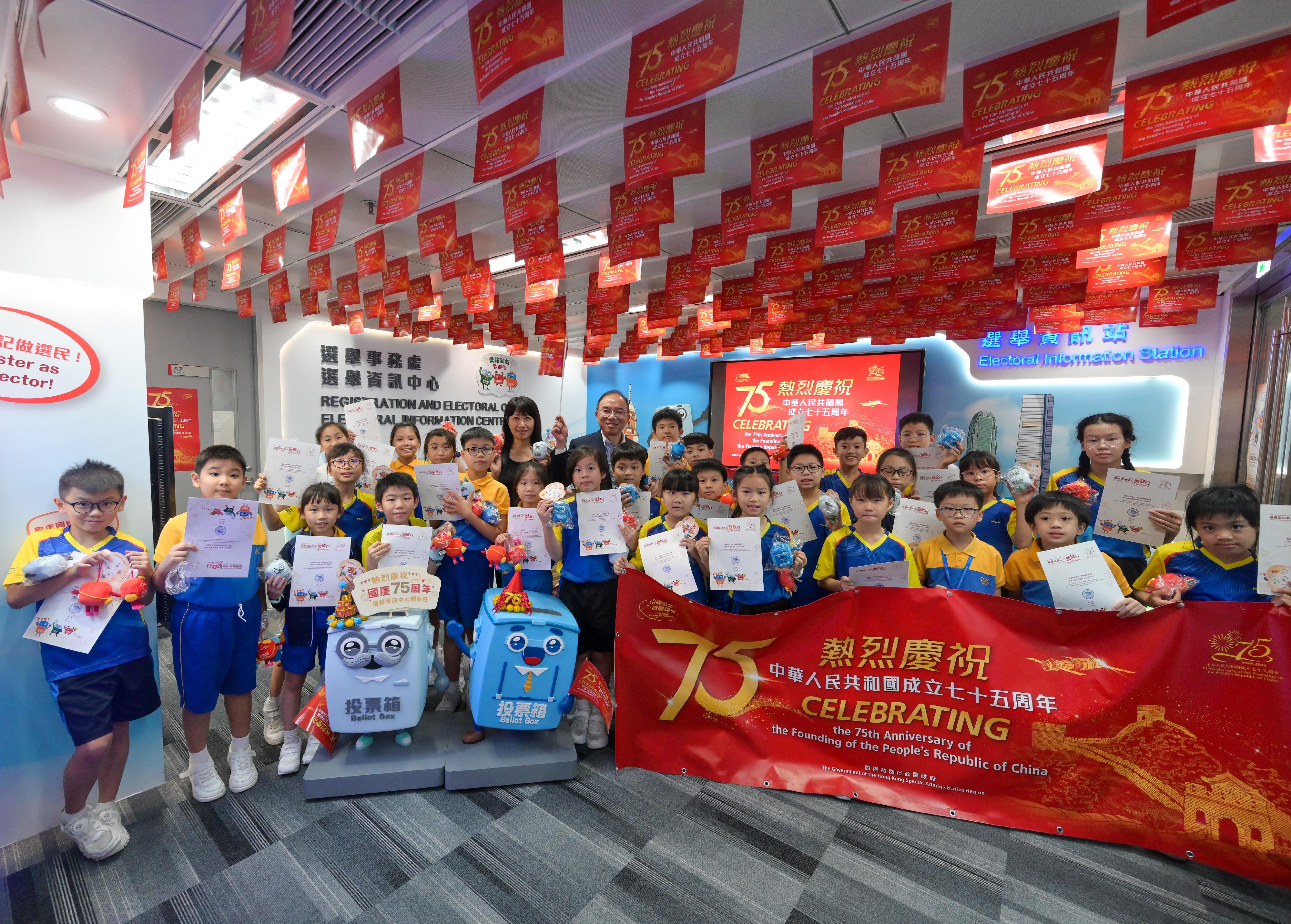 To celebrate the 75th anniversary of the founding of the People's Republic of China, the Electoral Information Centre of the Registration and Electoral Office (REO) is holding National Day Open Days for three consecutive days from today (September 30). The Secretary for Constitutional and Mainland Affairs, Mr Erick Tsang Kwok-wai, attended a guided tour for a group of senior primary school students this afternoon. Photo shows Mr Tsang (back row, fifth left), and the Chief Electoral Officer of the REO, Ms Natalie Chan (back row, fourth left), with the students.