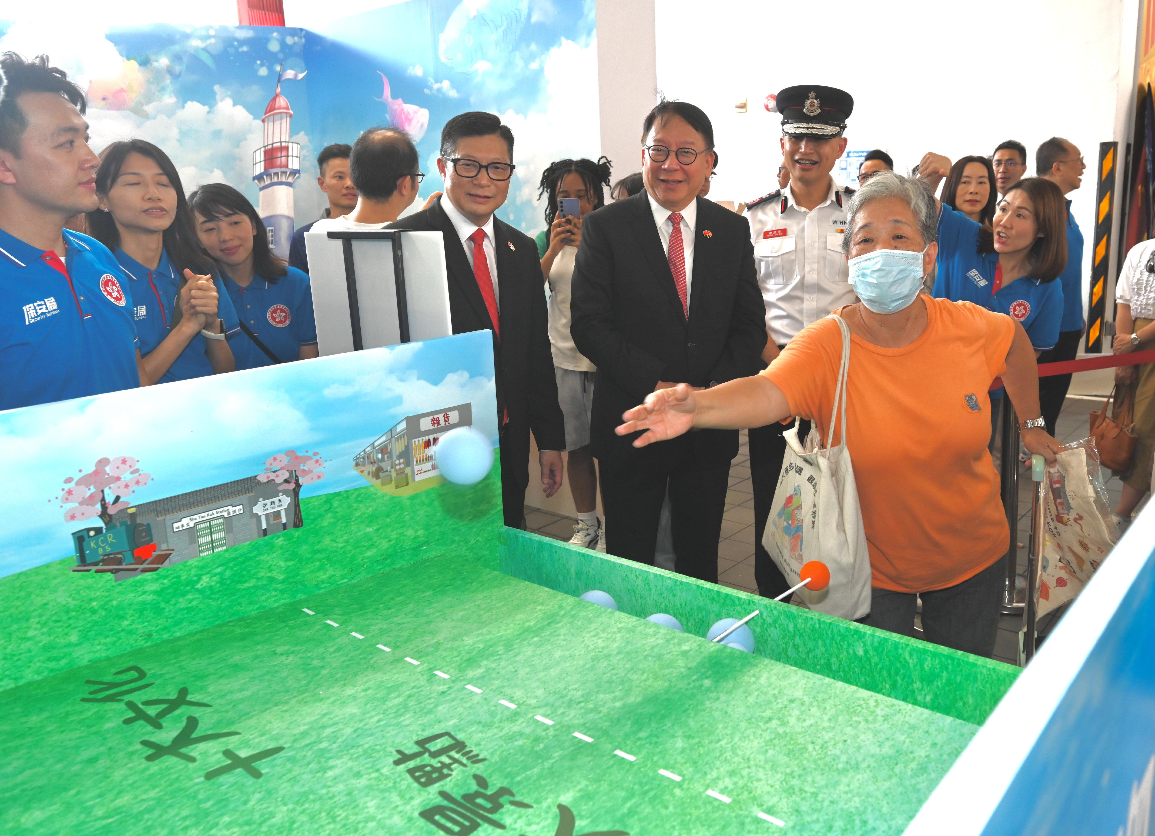 The Chief Secretary for Administration, Mr Chan Kwok-ki, attended the Grand Parade by Disciplined Services and Youth Groups cum Fun Day for Celebrating the 75th Anniversary of the Founding of the People's Republic of China today (October 1). Photo shows Mr Chan (front row, second right) touring the exhibition and game booths. Looking on is the Secretary for Security, Mr Tang Ping-keung (front row, third right).