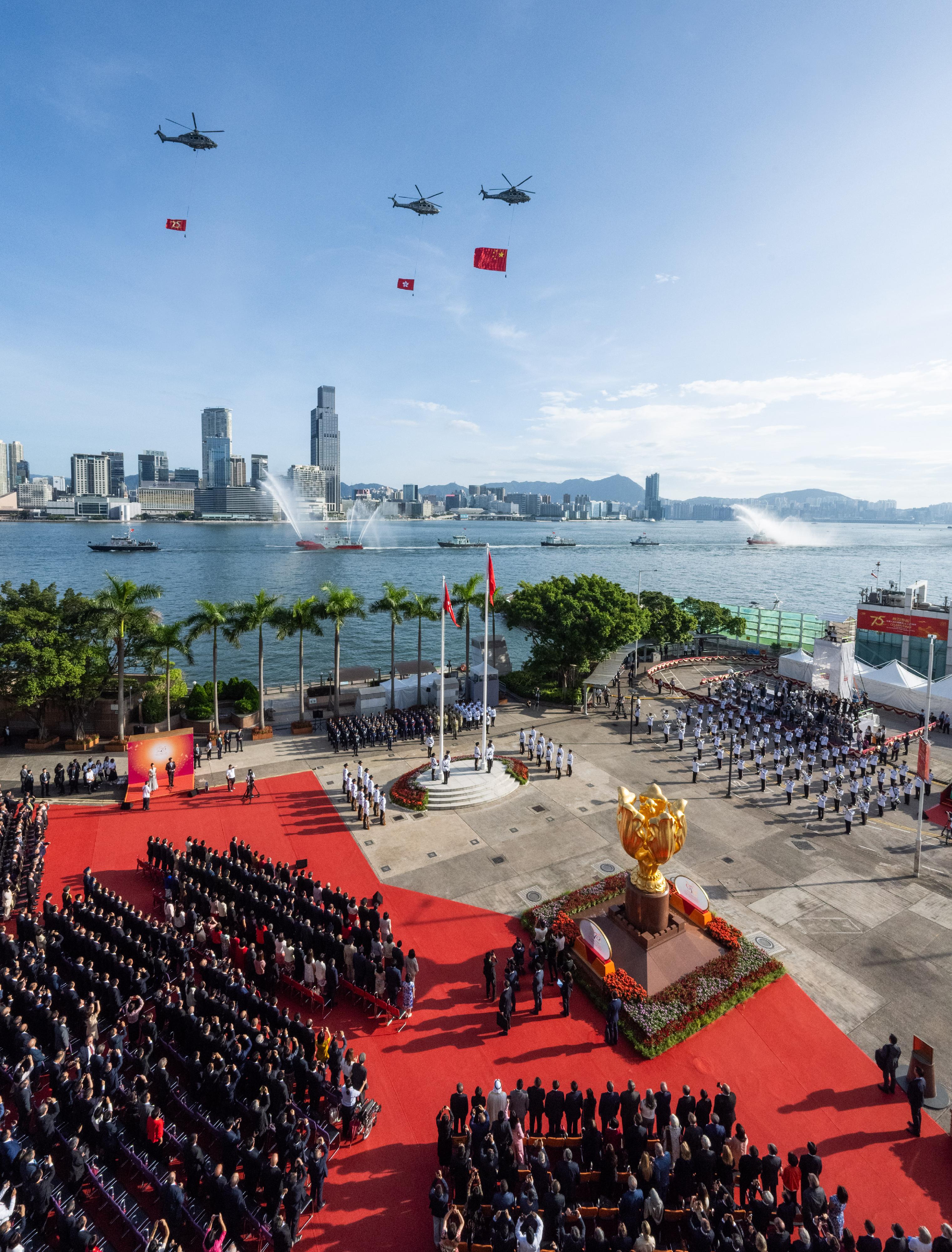 今早（十月一日）在湾仔金紫荆广场举行的庆祝中华人民共和国成立七十五周年升旗仪式上，纪律部队和飞行服务队在海上和空中敬礼。