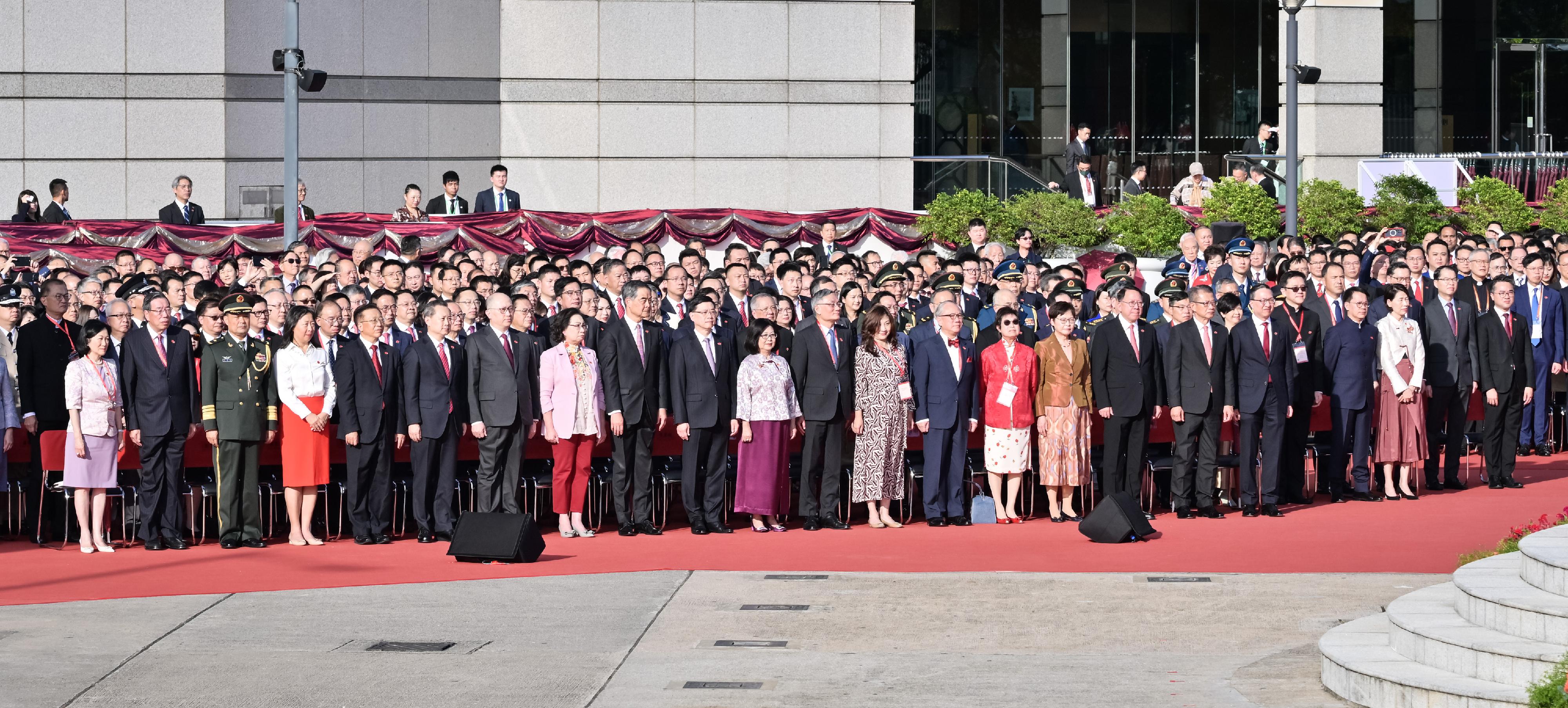 行政长官李家超（前排左十）及其夫人（前排左十一）、终审法院首席法官张举能（前排右八）及其夫人（前排右七）、前任行政长官曾荫权（前排右六）及其夫人（前排右五）、全国政协副主席梁振英（前排左九）及其夫人（前排左八）、前任行政长官林郑月娥（前排右四）、中央人民政府驻香港特别行政区联络办公室主任郑雁雄（前排左七）、中央人民政府驻香港特别行政区维护国家安全公署署长董经纬（前排左六）、外交部驻香港特别行政区特派员公署特派员崔建春（前排左五）及其夫人（前排左四）、中国人民解放军驻香港部队司令员彭京堂少将（前排左三）、政务司司长陈国基（前排右三）、财政司司长陈茂波（前排右二）、律政司司长林定国资深大律师（前排右一）、立法会主席梁君彦（前排左二）、行政会议非官守议员召集人叶刘淑仪（前排左一）和其他主要官员及嘉宾今早（十月一日）在湾仔金紫荆广场出席庆祝中华人民共和国成立七十五周年升旗仪式。