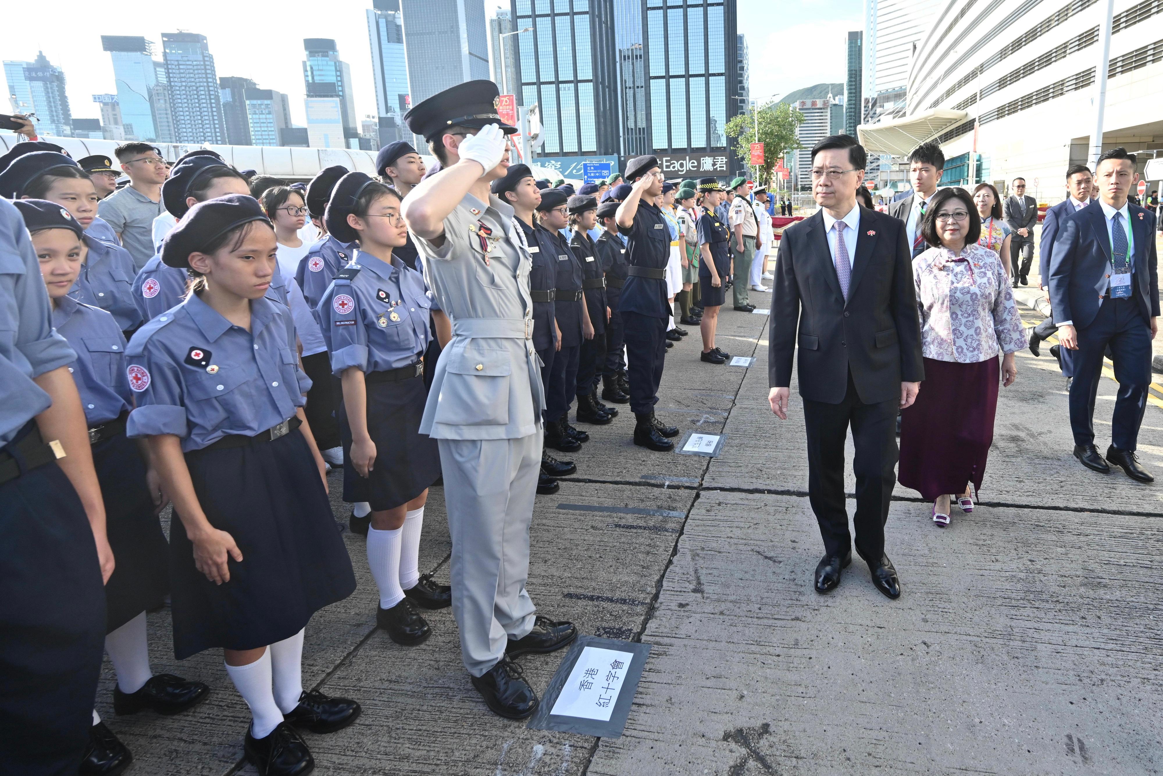 The Chief Executive, Mr John Lee, together with Principal Officials and guests, attends the flag-raising ceremony for the 75th anniversary of the founding of the People's Republic of China at Golden Bauhinia Square in Wan Chai this morning (October 1). Photo shows Mr Lee (third right) receiving salute by uniformed groups.