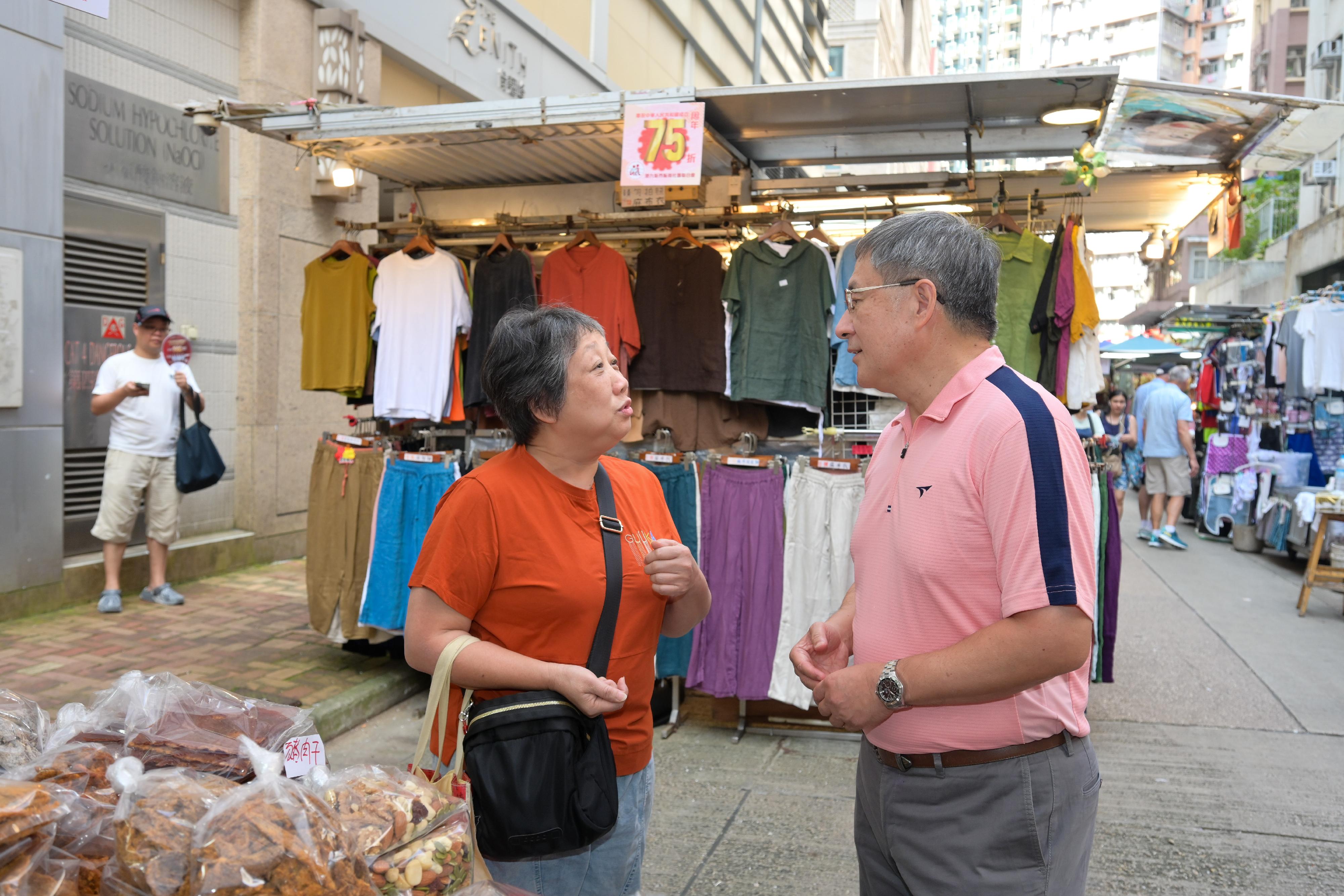 The Deputy Chief Secretary for Administration, Mr Cheuk Wing-hing (right), chats with members of the public at the Cross Street Outdoor Market in Wan Chai today (October 1). 