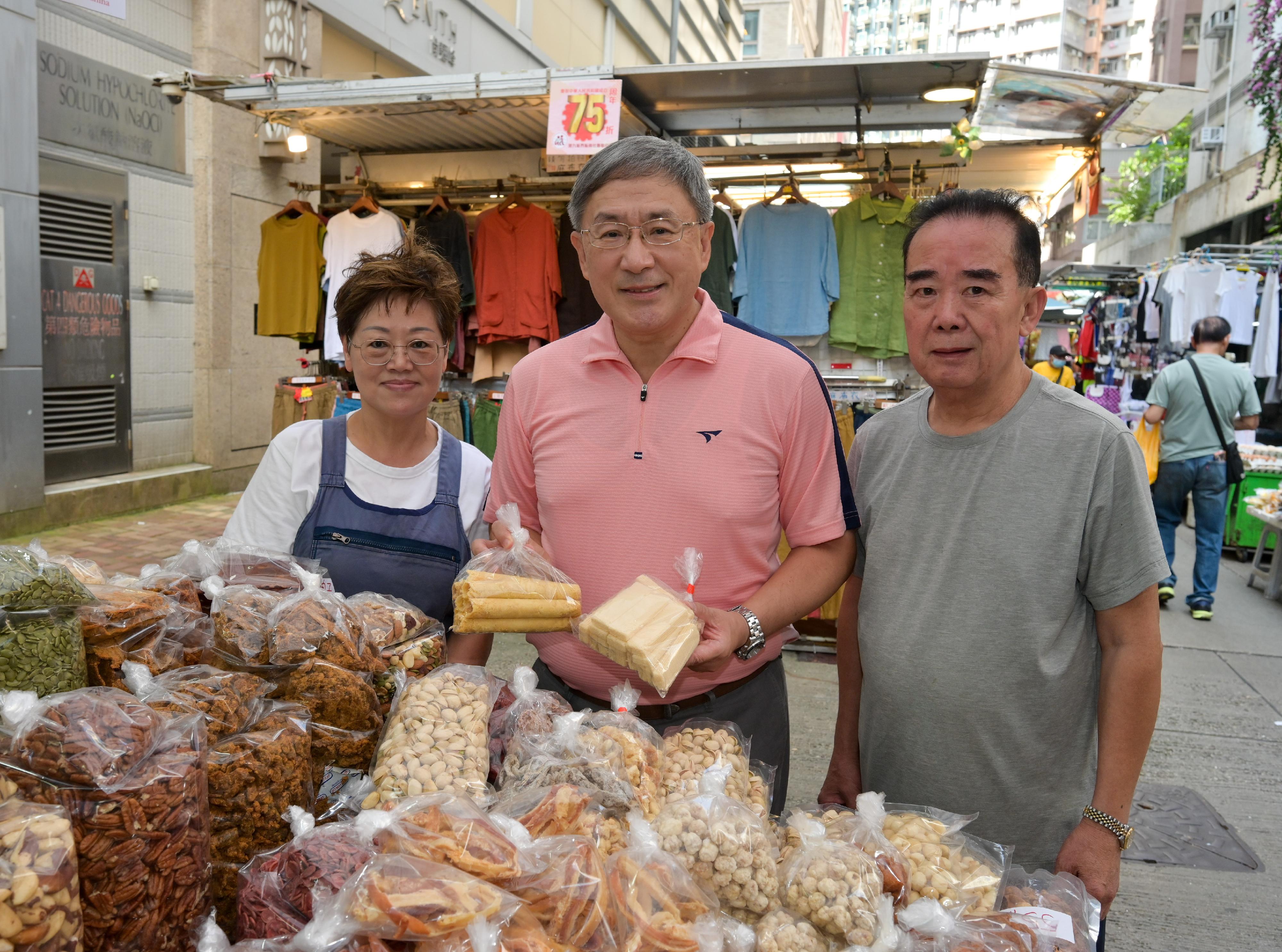 The Deputy Chief Secretary for Administration, Mr Cheuk Wing-hing (centre), is photographed with preserved fruit retailers who have joined shopping offers in celebration of the 75th anniversary of the founding of the People's Republic of China at the Cross Street Outdoor Market in Wan Chai today (October 1).