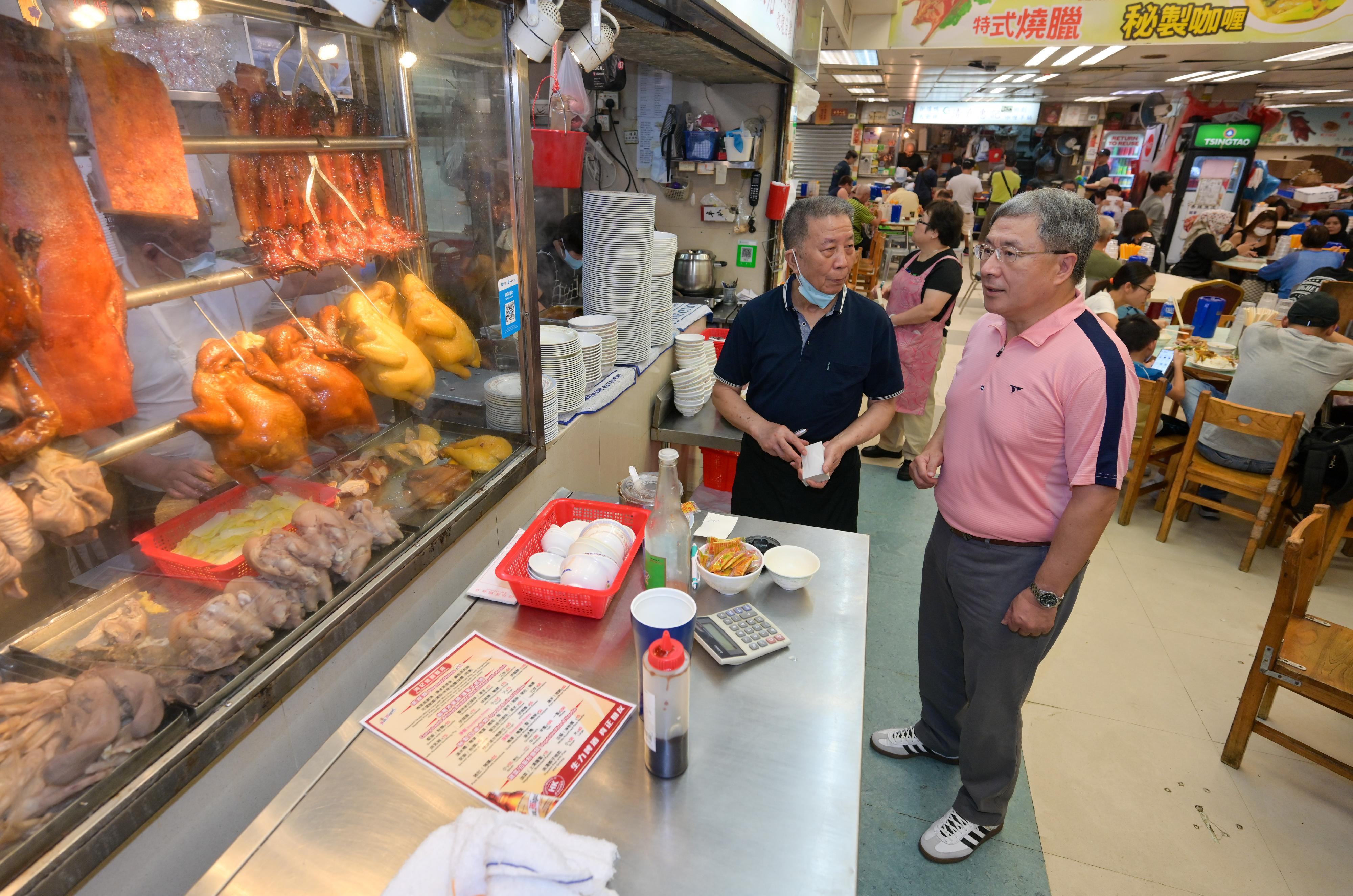 The Deputy Chief Secretary for Administration, Mr Cheuk Wing-hing (right), buys takeaway roasted meat at a discount of 25 per cent at Wan Chai Bowrington Road Cooked Food Centre today (October 1).