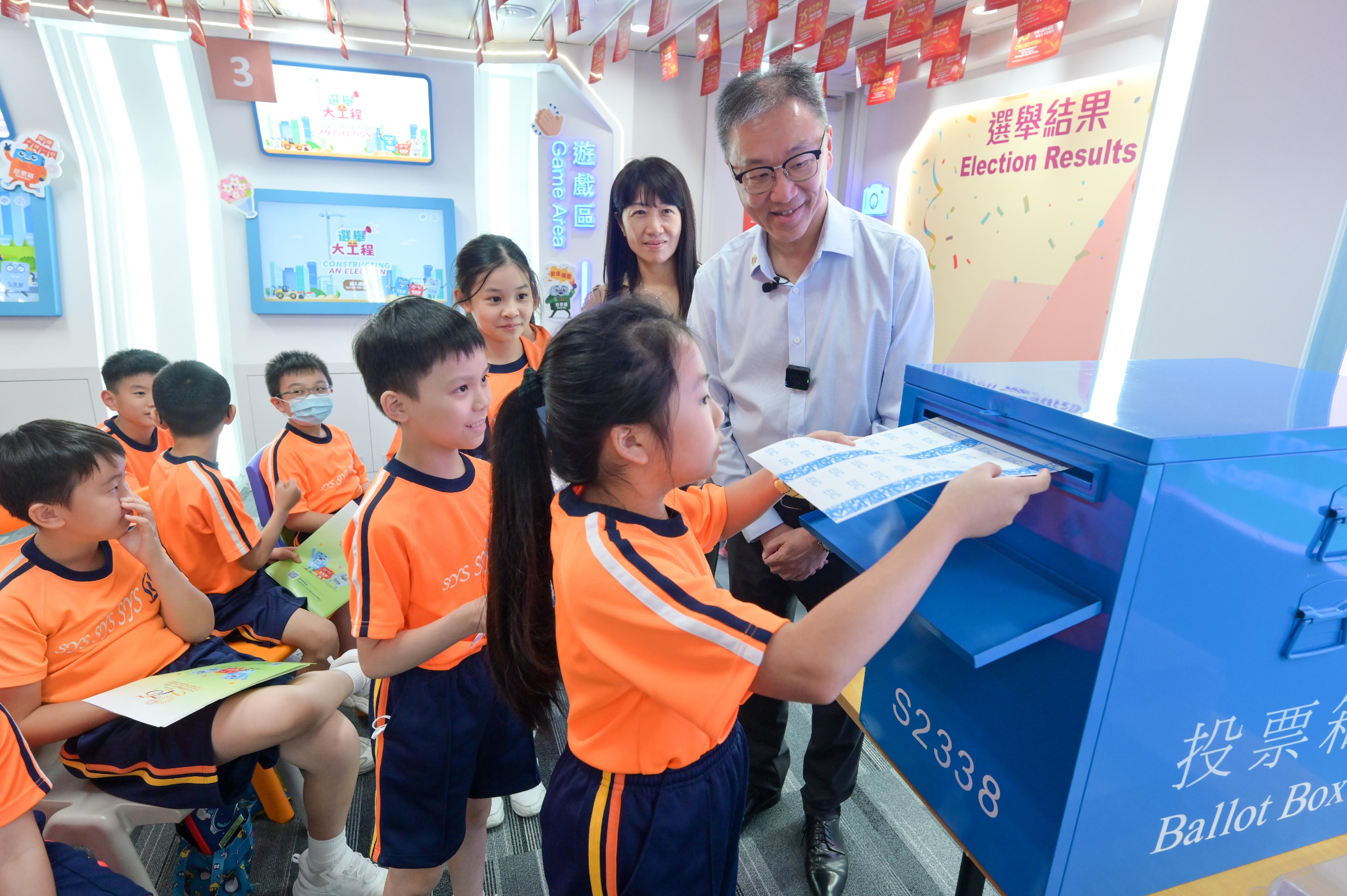 To celebrate the 75th anniversary of the founding of the People's Republic of China, the Electoral Information Centre of the Registration and Electoral Office (REO) is holding National Day Open Days for three consecutive days from September 30. The Chairman of the Electoral Affairs Commission, Mr Justice David Lok, today (October 2) hosted the guided tour on the third day of the Open Days and shared the joy of National Day with a group of senior primary school students. Photo shows Mr Justice Lok (back row, first right) and students during the mock polling session. Also present is the Chief Electoral Officer of the REO, Ms Natalie Chan (back row, second right).