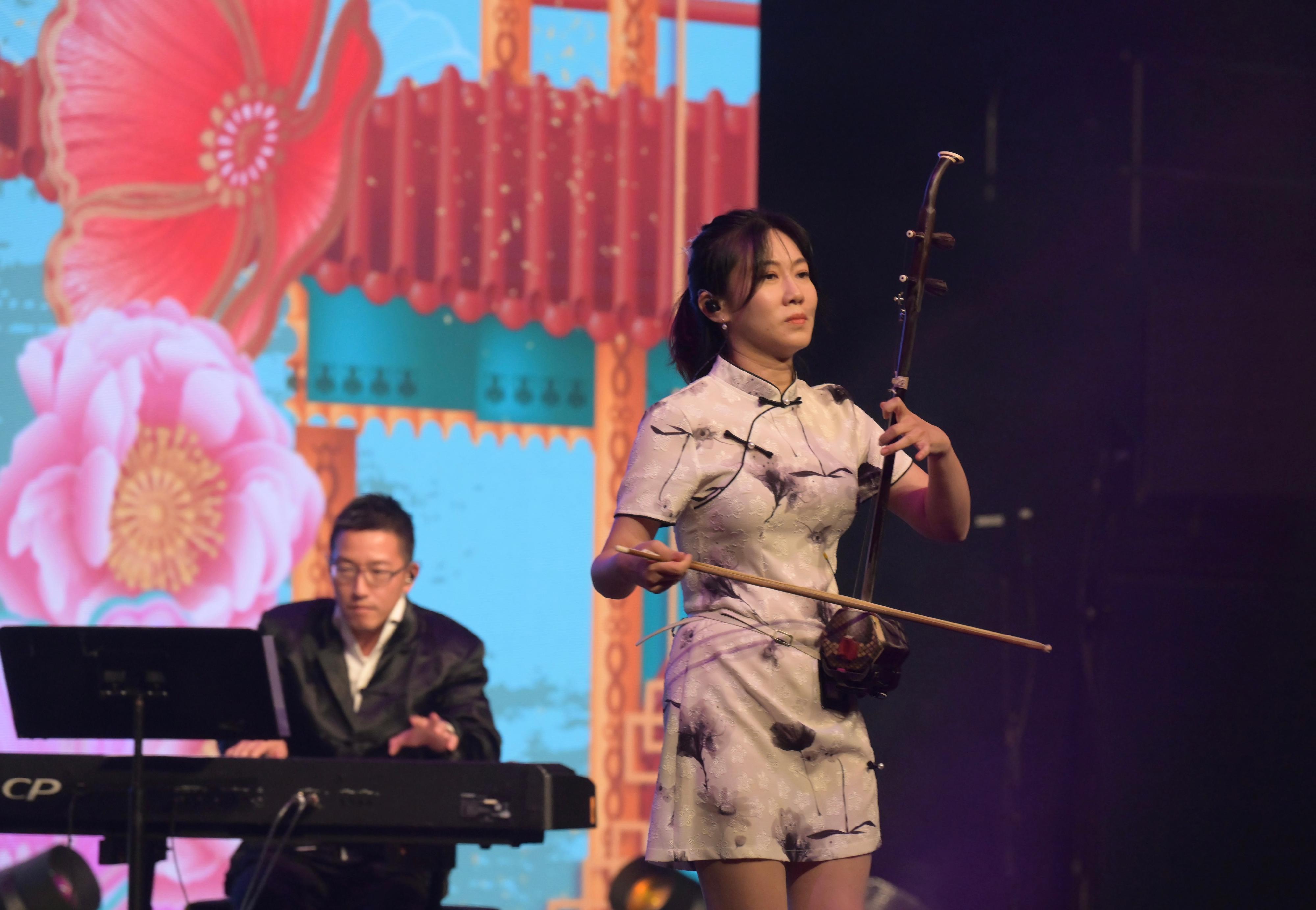 To celebrate the 75th anniversary of the founding of the People's Republic of China, the Culture, Sports and Tourism Bureau and the Leisure and Cultural Services Department held the "Celebration of National Day - A Thousand Youths in Chinese Costumes" evening gala on October 4 at the Queen Elizabeth Stadium in Wan Chai. Photo shows huqin artist Chan Pik-sum (front) and pianist Phoebus Chan (back) performing at the gala.

