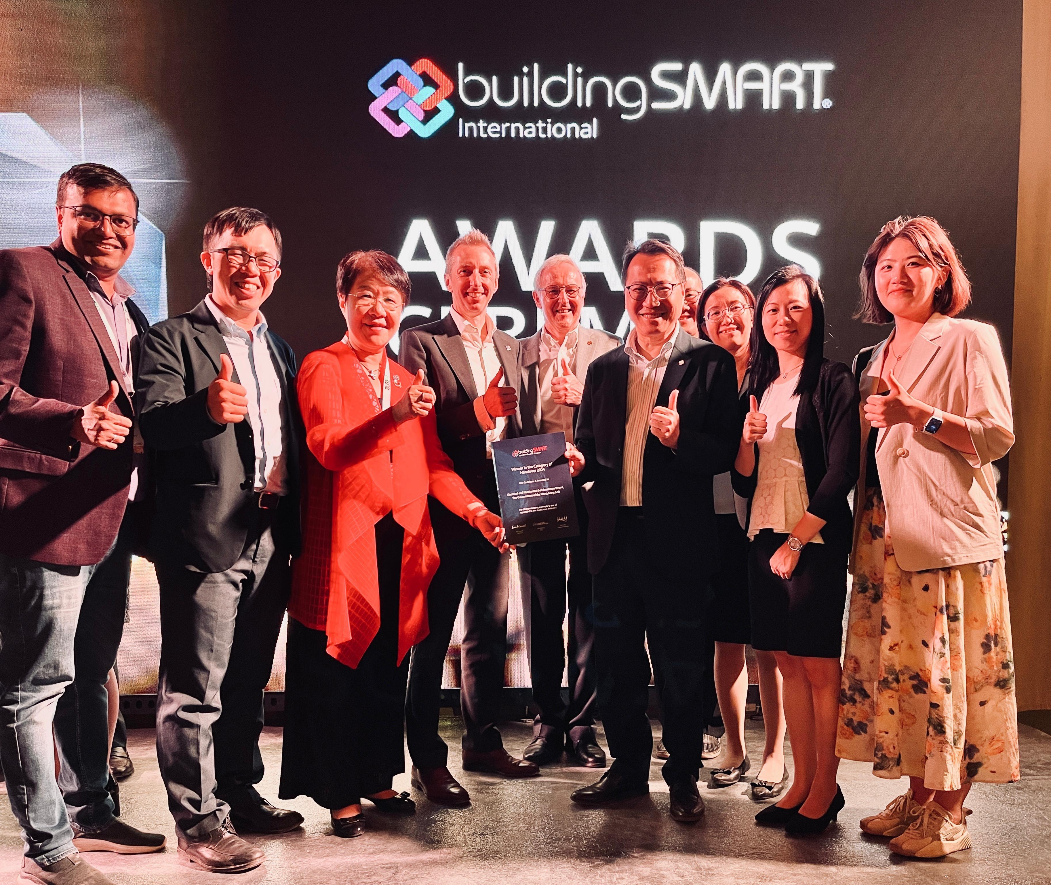 The Electrical and Mechanical Services Department (EMSD) received the grand award under the "Handover" category of the openBIM Awards 2024 at an award presentation ceremony held in Marrakesh, Morocco, on October 3 (Morocco time). Photo shows the Chief Engineer of the EMSD, Mr Steve Chan, (front row, third right), and his team receiving the award from the representatives of the organiser, buildingSMART International.