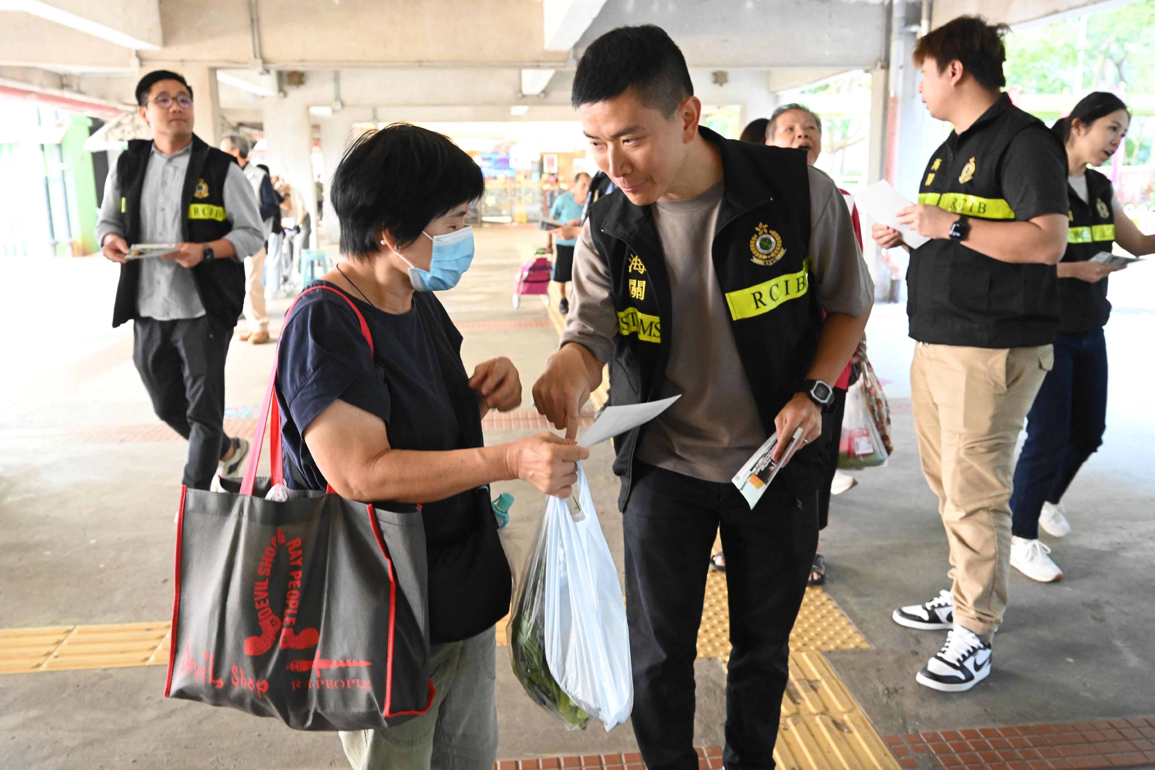 香港海关昨日和今日（十月七和八日）联同立法会议员、多位九龙东区议员、卫生署控烟酒办公室、警务处及社区关爱队在多个公共屋邨宣传反私烟讯息。图示海关人员向居民派发宣传单张。