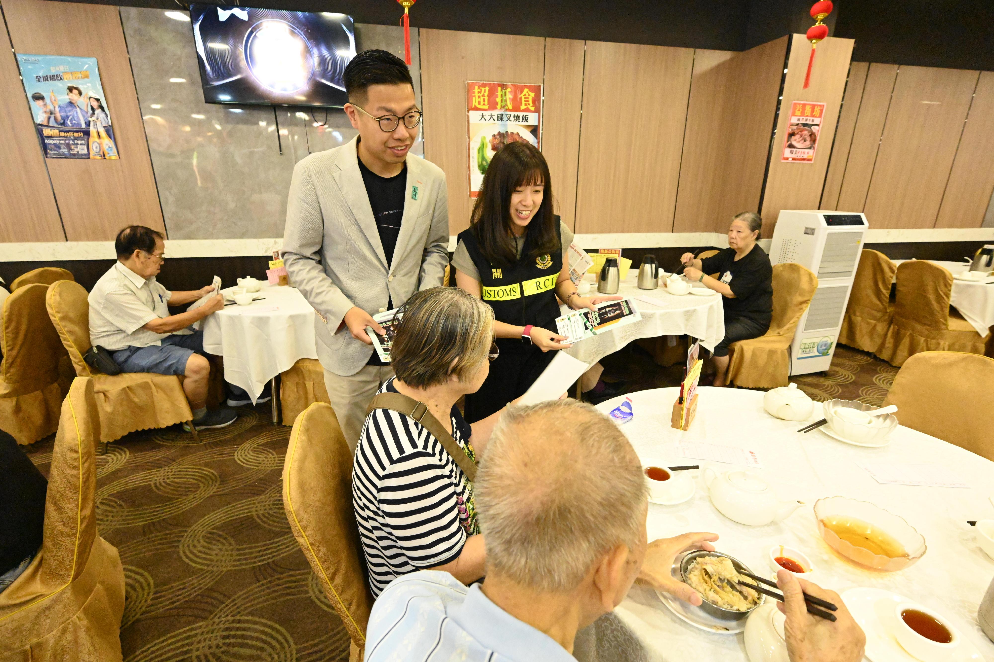 香港海关昨日和今日（十月七和八日）联同立法会议员、多位九龙东区议员、卫生署控烟酒办公室、警务处及社区关爱队在多个公共屋邨宣传反私烟讯息。图示海关人员与区议员于食肆向居民宣传反私烟。