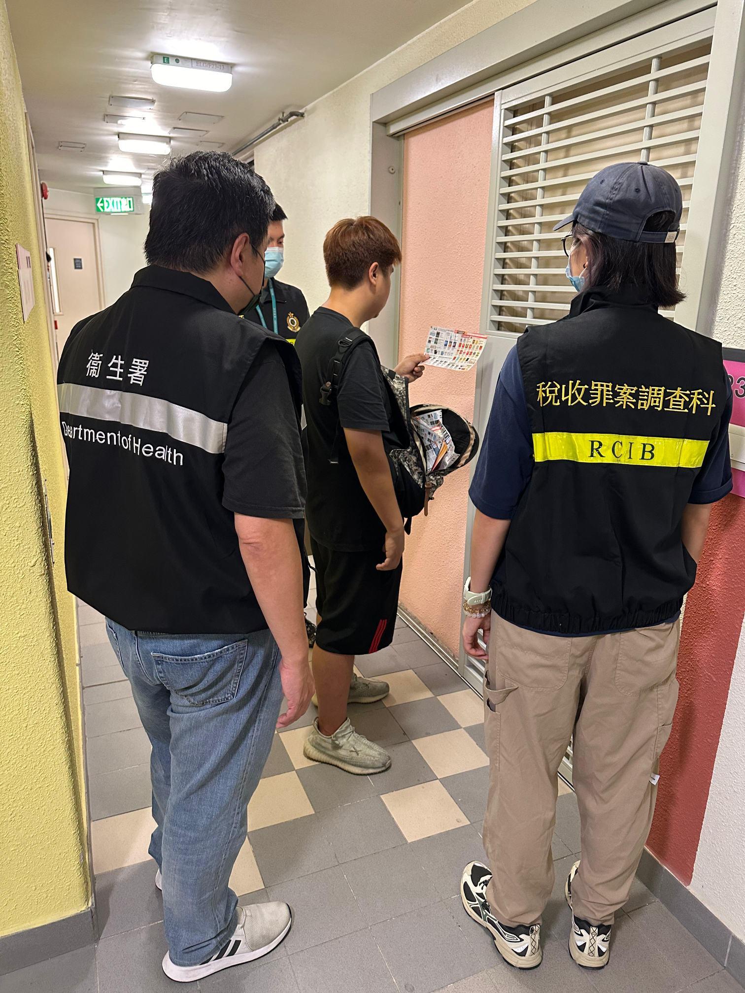 To step up enforcement actions against distribution of illicit cigarette leaflets in public housing estates, the Tobacco and Alcohol Control Office (TACO) of the Department of Health (DH) and the Hong Kong Customs and Excise Department (C&ED) launched a joint operation codenamed "Thunder" in various districts across Hong Kong between September 19 and October 6. Photo shows officers of TACO of the DH conducting inspections with the C&ED officers at Mun Tung Estate in Tung Chung against a man suspected of distributing smoking product advertisements.