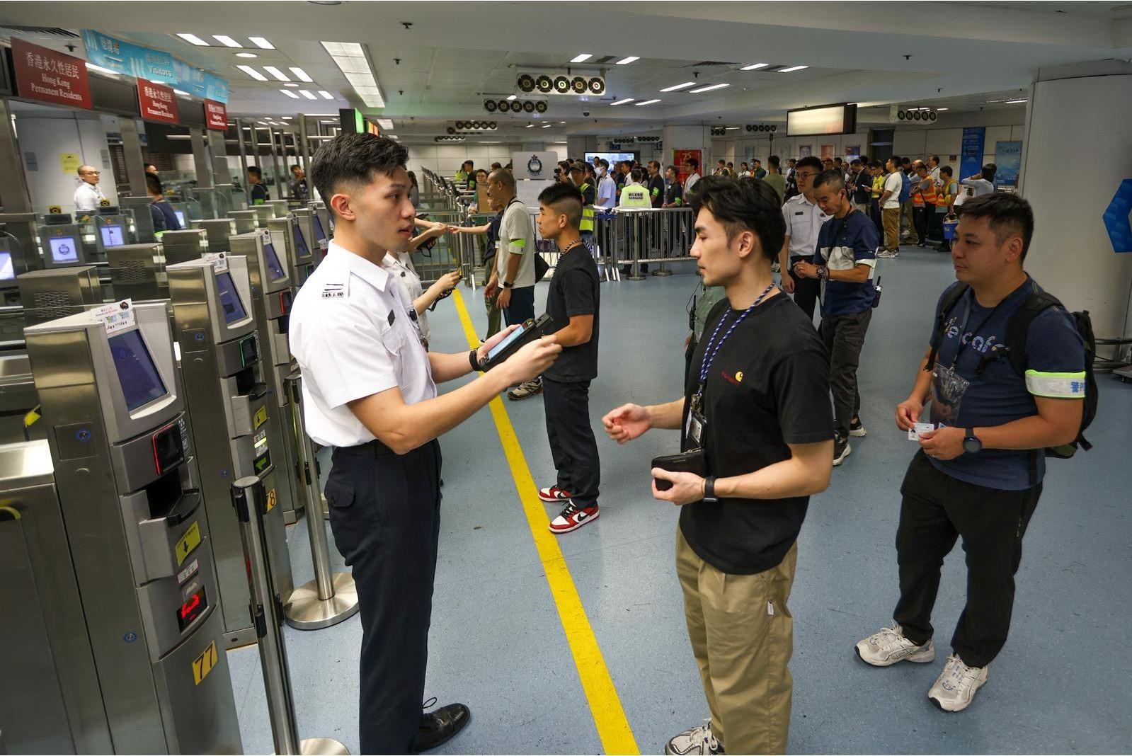 入境事务处（入境处）今日（十月九日）与香港警务处、香港海关、机电工程署、运输署、香港铁路有限公司及中华电力有限公司在罗湖管制站进行联合演练以应对供电及系统网络事故。图示在模拟事故发生后入境处为旅客办理出入境手续的情况。