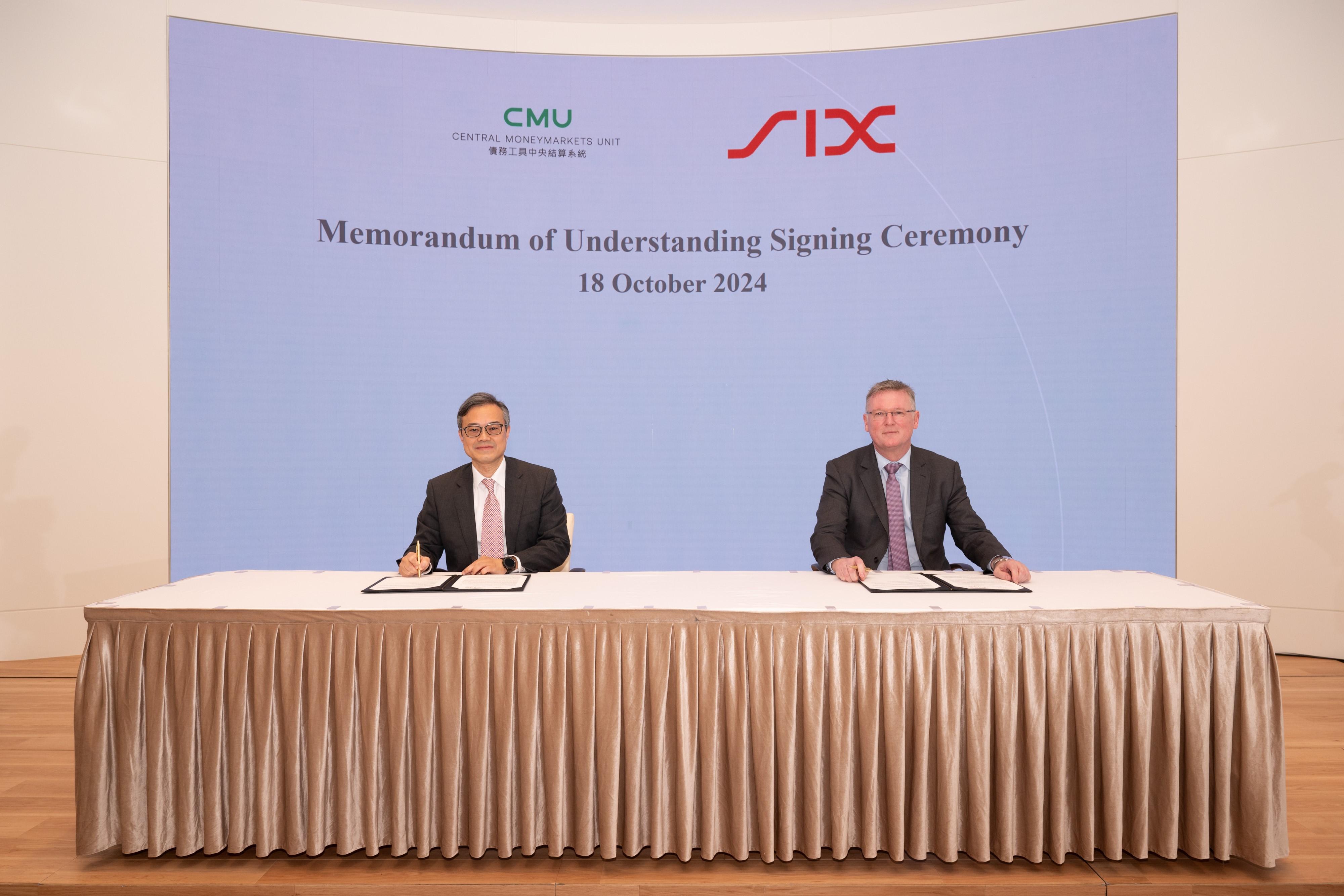 The CEO of CMU OmniClear Limited, Mr Stanley Chan (left), and Global Head of Commercials, Securities Services at SIX, Mr Marcus Harréus (right), sign a Memorandum of Understanding to promote collaboration in securities depository and settlement.