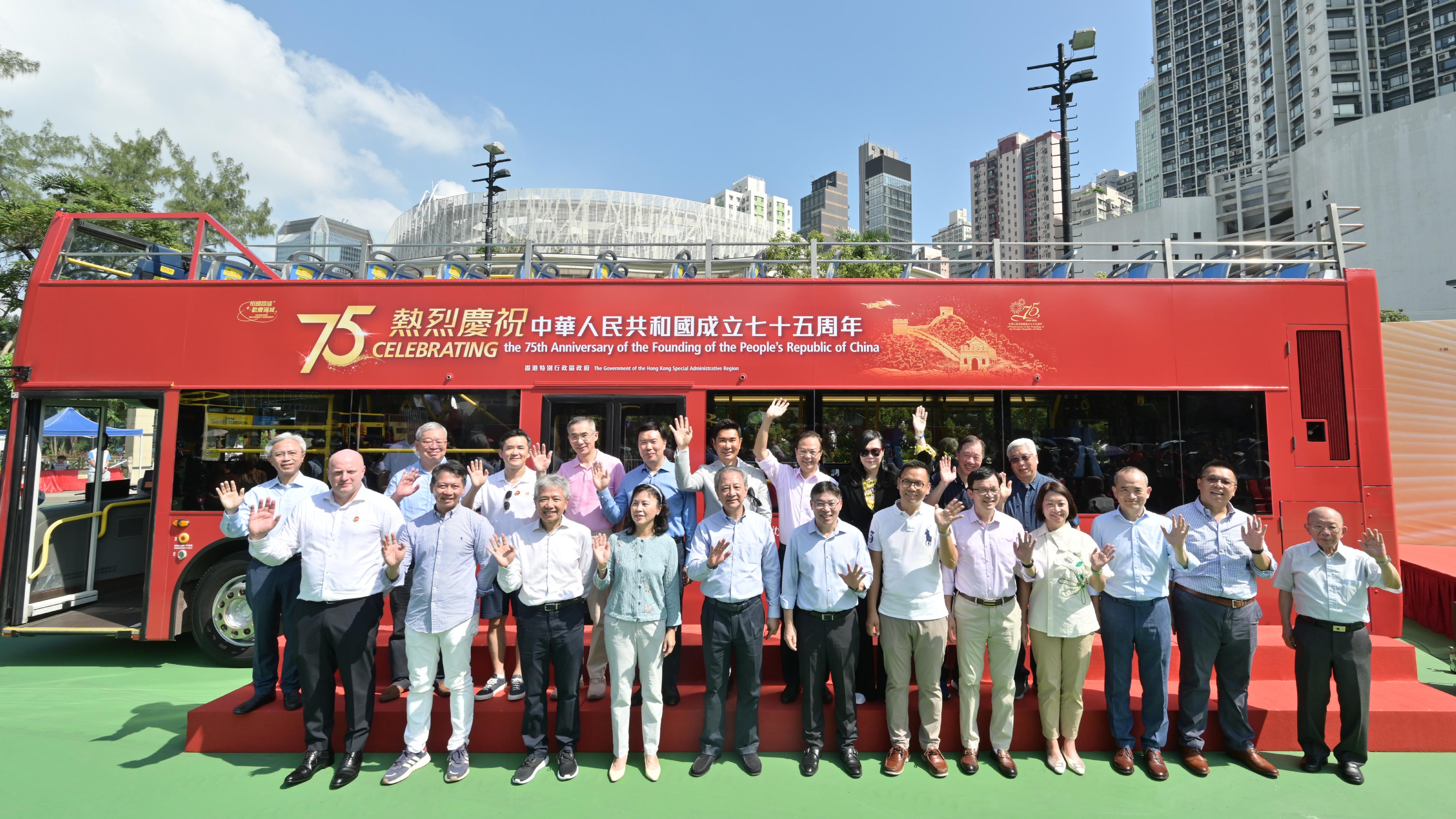 The Secretary for Transport and Logistics, Mr Lam Sai-hung, today (October 19) officiated at the kick-off ceremony of the Bus Parade cum Exhibition for Celebrating the 75th Anniversary of the Founding of the People's Republic of China organised by the Transport Department. It is one of the highlight events amid National Day celebrations this year. Photo shows (front row, from left) the Managing Director of Citybus, Mr Richard Hall; the Director of Broadcasting, Mr Eddie Cheung; the Chairman of the Transport Advisory Committee, Professor Stephen Cheung; the Permanent Secretary for Transport and Logistics, Ms Mable Chan; Legislative Council (LegCo) Member (Transport) Mr Frankie Yick; Mr Lam; the Chairman of the LegCo Panel on Transport, Dr Chan Han-pan; the Under Secretary for Transport and Logistics, Mr Liu Chun-san; the Commissioner for Transport, Ms Angela Lee; the Managing Director of the Kowloon Motor Bus Co. (1933) Ltd, Mr Roger Lee; the Managing Director of New Lantao Bus Company (1973) Limited, Mr James Wong; and guests in front of the open-top bus themed on the 75th National Day.
