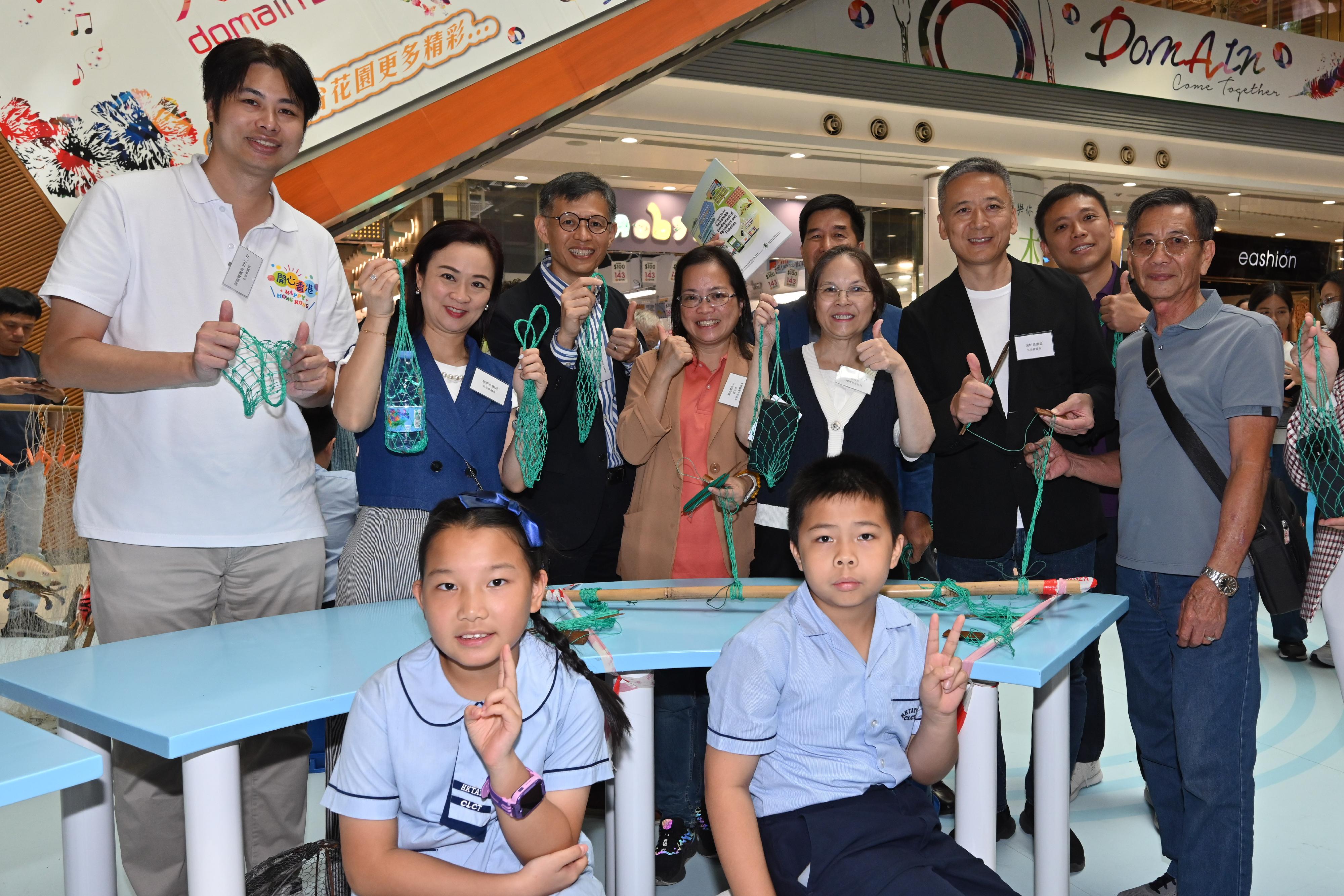 The Agriculture, Fisheries and Conservation Department is holding the "Sail into Fun" Leisure Fisheries Expo today and tomorrow (October 19 and 20) at Domain Mall in Yau Tong. Photo shows the Under Secretary for Environment and Ecology, Miss Diane Wong (back row, fourth right); Legislative Council Members Mr Steven Ho (back row, first left), Mr Yiu Pak-leung (back row, third right), Ms Chan Hoi-yan (back row, second left); the Director of Agriculture, Fisheries and Conservation, Mr Mickey Lai (back row, third left); the Chairperson of the Sustainable Fisheries Development Fund Advisory Committee, Dr Yau Wing-kwong (back row, fifth right) and Vice Chairman of the Hong Kong Fishermen Consortium Ms Lau Kam-fung (back row, fourth left) experiencing fish net weaving with students under the guidance of fishermen.