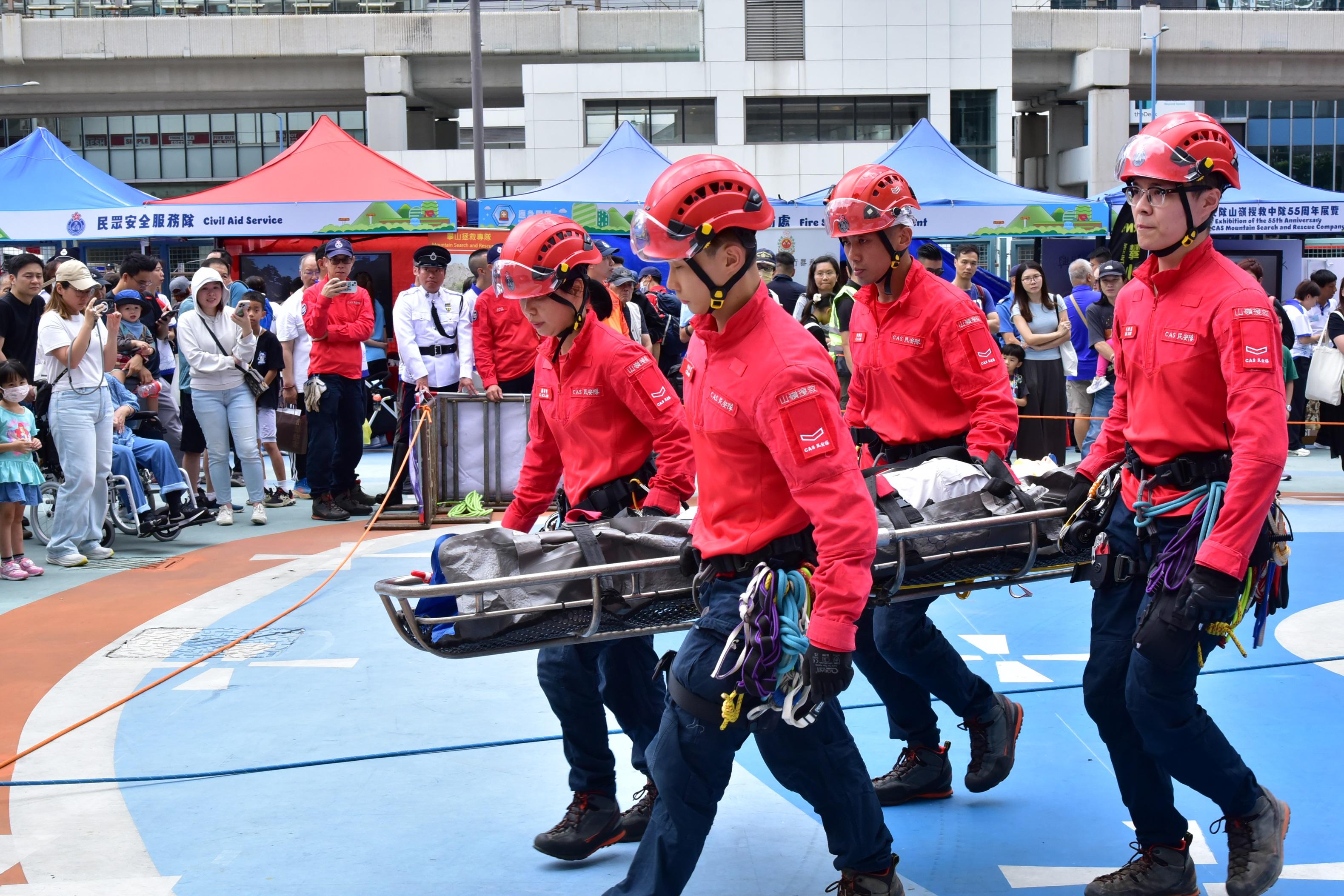 民众安全服务队（民安队）今日（十月二十日）联同多个政府部门和山岭活动团体在观塘市中心自由空间举办「二○二四山岭活动安全推广日暨民安队山岭搜救中队成立五十五周年」。图示民安队队员展示山岭搜救技术。