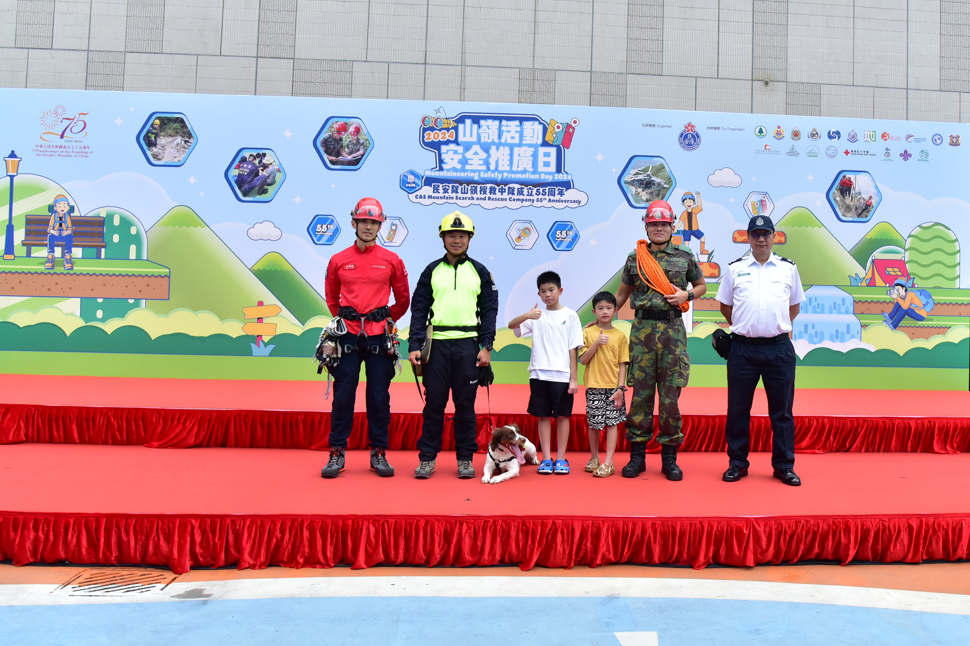 The Civil Aid Service (CAS) held the Mountaineering Safety Promotion Day 2024 and 55th Anniversary of the CAS Mountain Search and Rescue Company with various government departments and mountaineering organisations today (October 20) at the Free Space, Kwun Tong Town Centre. Photo shows members of the public with rescue personnel.