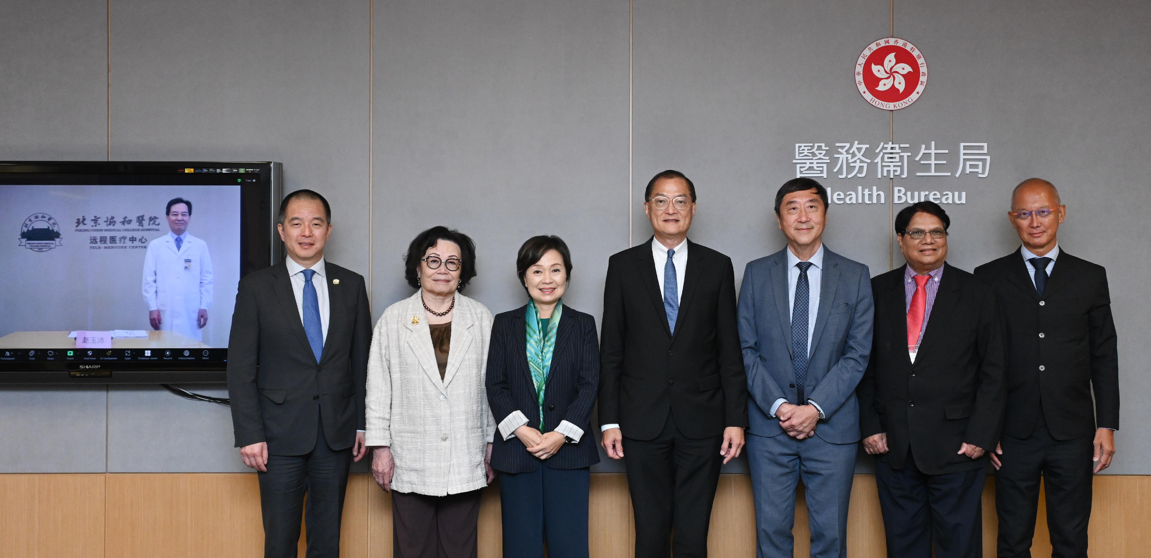 The Secretary for Health, Professor Lo Chung-mau, and the Secretary for Education, Dr Choi Yuk-lin, cochaired the first meeting of the Task Group on New Medical School today (October 22). Photo shows Professor Lo (centre) and Dr Choi (third left) with the six Expert Advisors, namely the Chairman of the Medical Council of Hong Kong, Professor Grace Tang (second left); the President of the Hong Kong Academy of Medicine, Professor Gilberto Leung (first left); Professor Nivritti Gajanan Patil (second right); Professor Joseph Sung (third right); Professor Zhao Yupei (on screen); and Mr Philip Tsai (first right) before the meeting.