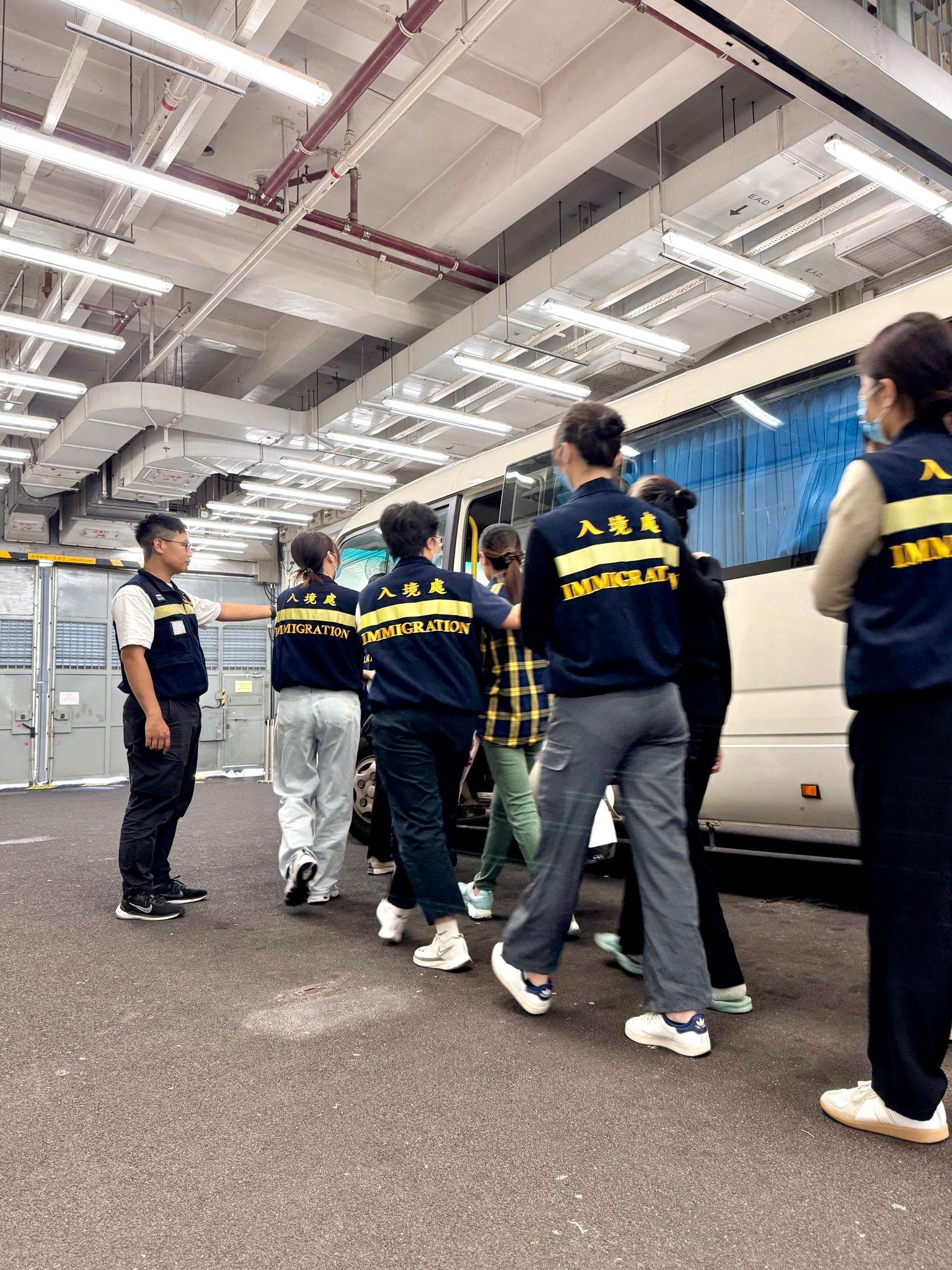 The Immigration Department (ImmD) carried out a repatriation operation today (October 23).  A total of 19 Vietnamese illegal immigrants were repatriated to Vietnam.  Photo shows removees being escorted by ImmD officers to proceed from the detention place to the airport.