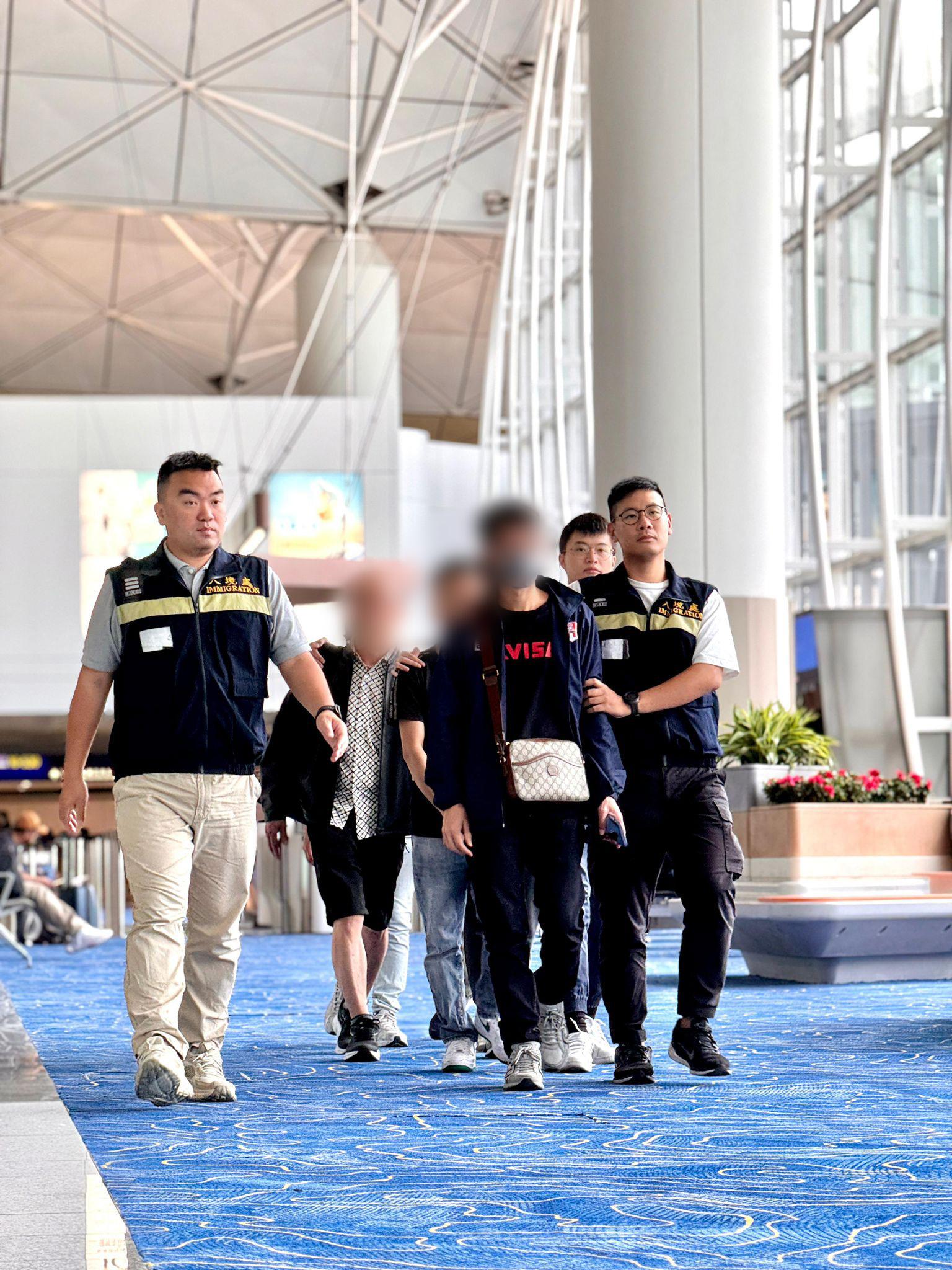 The Immigration Department (ImmD) carried out a repatriation operation today (October 23).  A total of 19 Vietnamese illegal immigrants were repatriated to Vietnam.  Photo shows removees being escorted by ImmD officers to depart from Hong Kong.