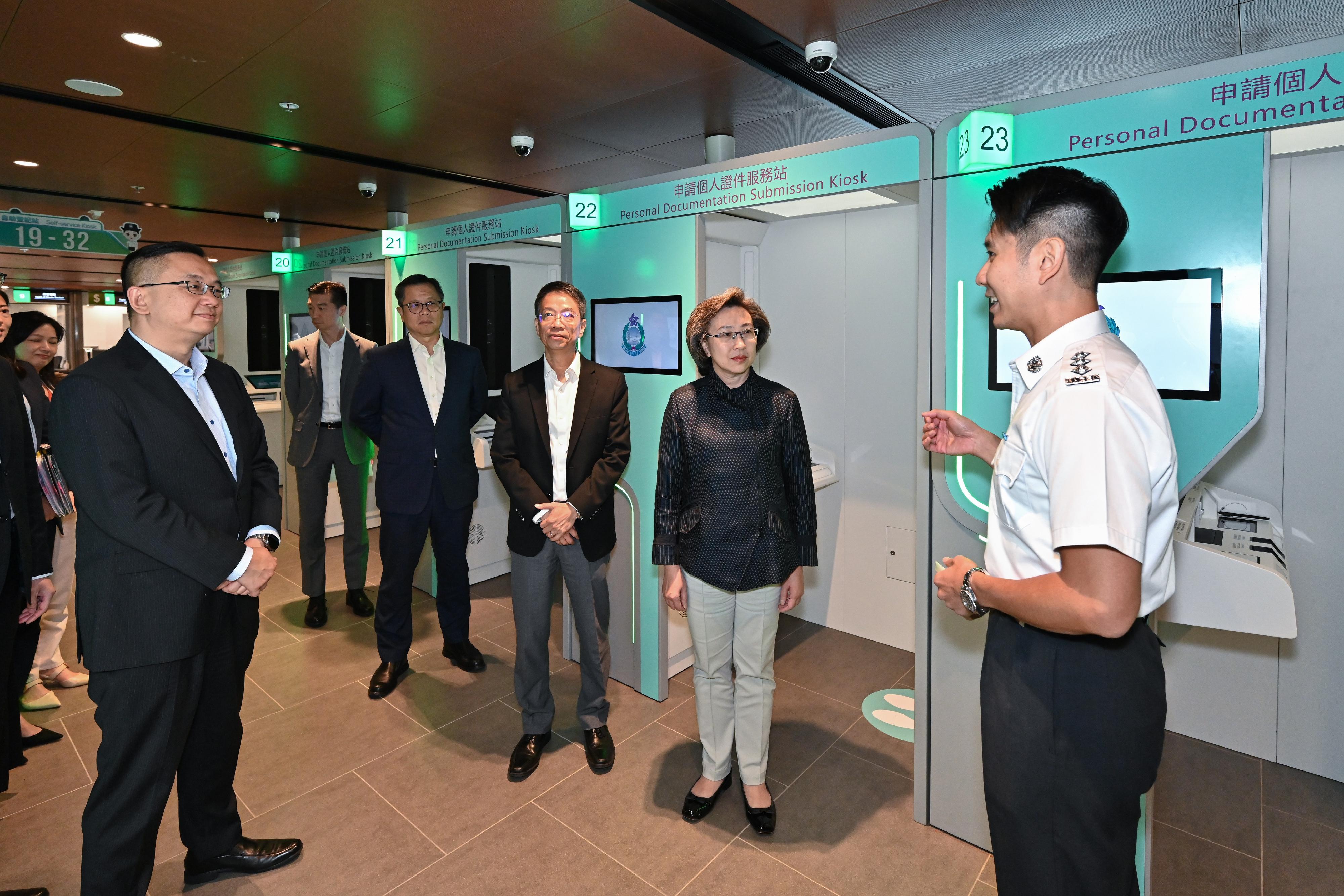 The Secretary for the Civil Service, Mrs Ingrid Yeung, visited the new headquarters of the Immigration Department (ImmD) in Tseung Kwan O today (October 24). Photo shows Mrs Yeung (second right) visiting the Registration of Persons Office where ImmD staff briefed her on the new Personal Documentation Submission Kiosks. Looking on are the Permanent Secretary for the Civil Service, Mr Clement Leung (third right), and the Director of Immigration, Mr Benson Kwok (first left).