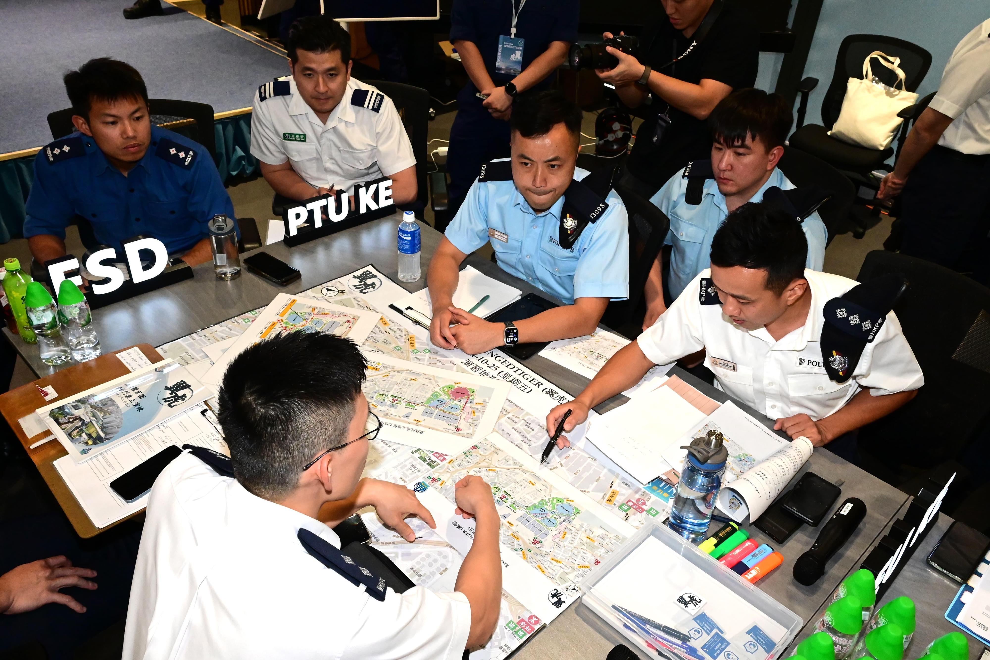 香港警务处东九龙总区行动部昨日（十月二十五日）在东九龙总部举行首个有关启德体育园的跨部门桌上演练。图示警方与政府部门及相关机构代表商讨应对可能发生的突发情境所采取的措施。