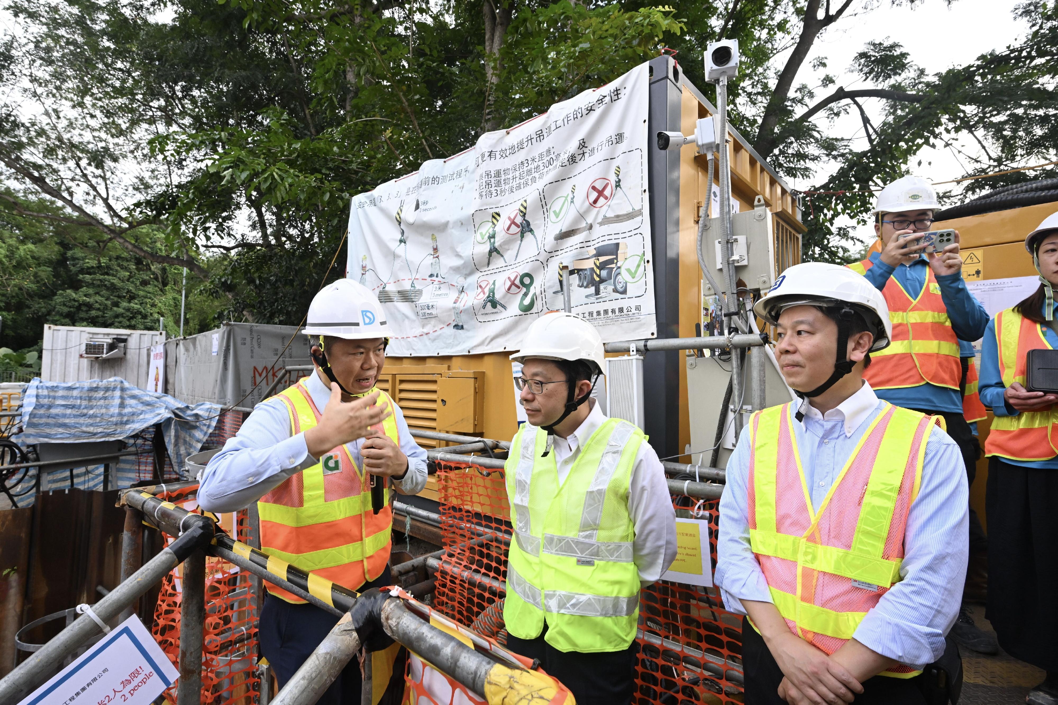 The Secretary for Labour and Welfare, Mr Chris Sun, visited a construction site today (October 28) to call on contractors, employers and workers to pay attention to work safety and health in confined space workplaces. Photo shows Assistant Director of the Drainage Services Department, Mr Raymond Lee (left) briefing Mr Sun (centre) and the Deputy Commissioner for Labour (Occupational Safety and Health), Mr Vincent Fung (right), on relevant measures of the Smart Site Safety System implemented at the site.