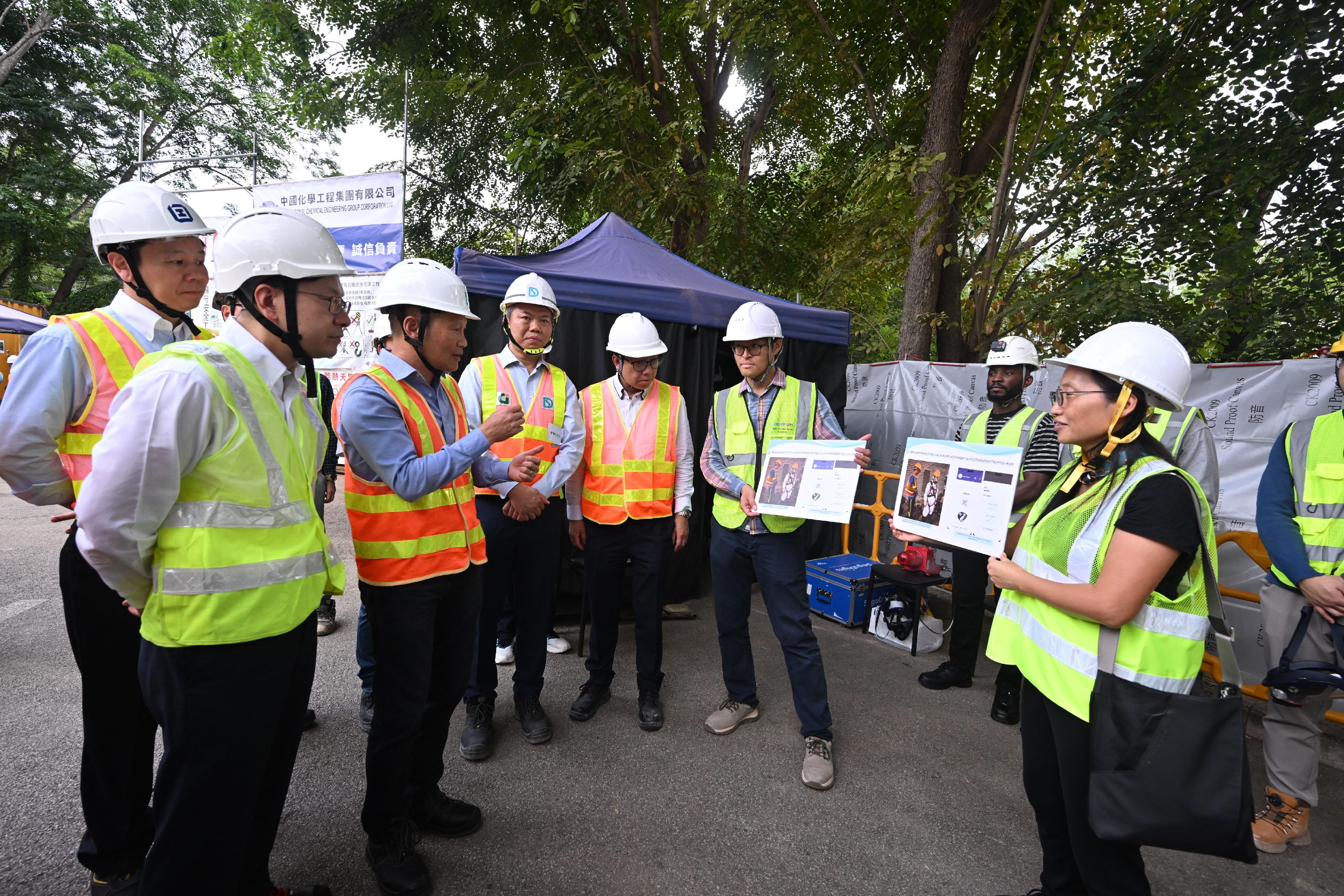 The Secretary for Labour and Welfare, Mr Chris Sun, visited a construction site today (October 28) to call on contractors, employers and workers to pay attention to work safety and health in confined space workplaces. Photo shows officers of the Drainage Services Department briefing Mr Sun (second left) and the Deputy Commissioner for Labour (Occupational Safety and Health), Mr Vincent Fung (first left), on relevant safety measures of confined space workplaces.