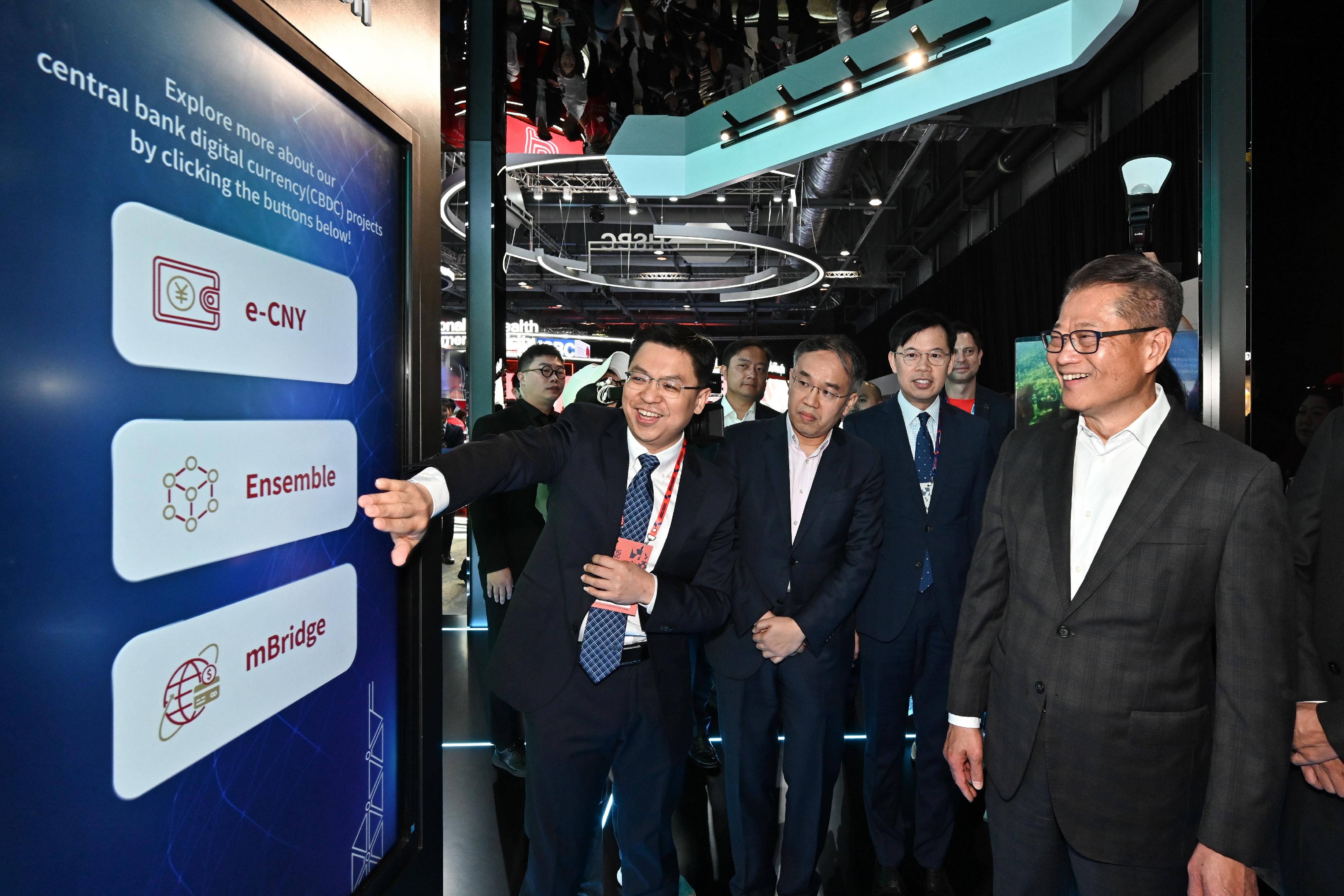 The Financial Secretary, Mr Paul Chan, attended Hong Kong FinTech Week 2024 today (October 28). Photo shows Mr Chan (first right), accompanied by the Secretary for Financial Services and the Treasury, Mr Christopher Hui (third right), visiting an exhibition booth.