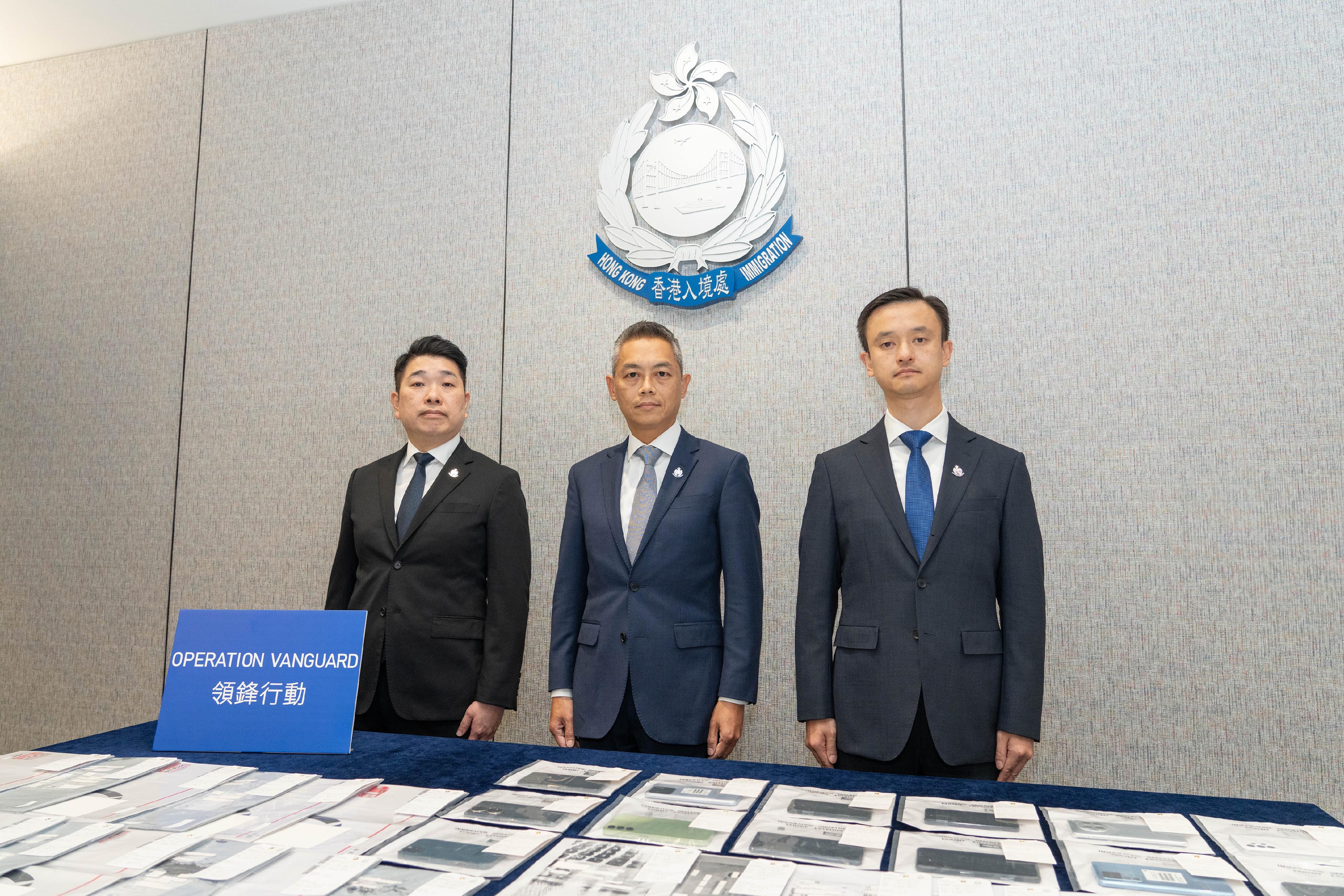 The Immigration Department and the Mainland authorities smashed a cross-boundary forgery syndicate. Photos shows Senior Principal Immigration Officer Mr So Chun-ho (centre) and investigators showing items seized in the operation during a press conference today (October 31).