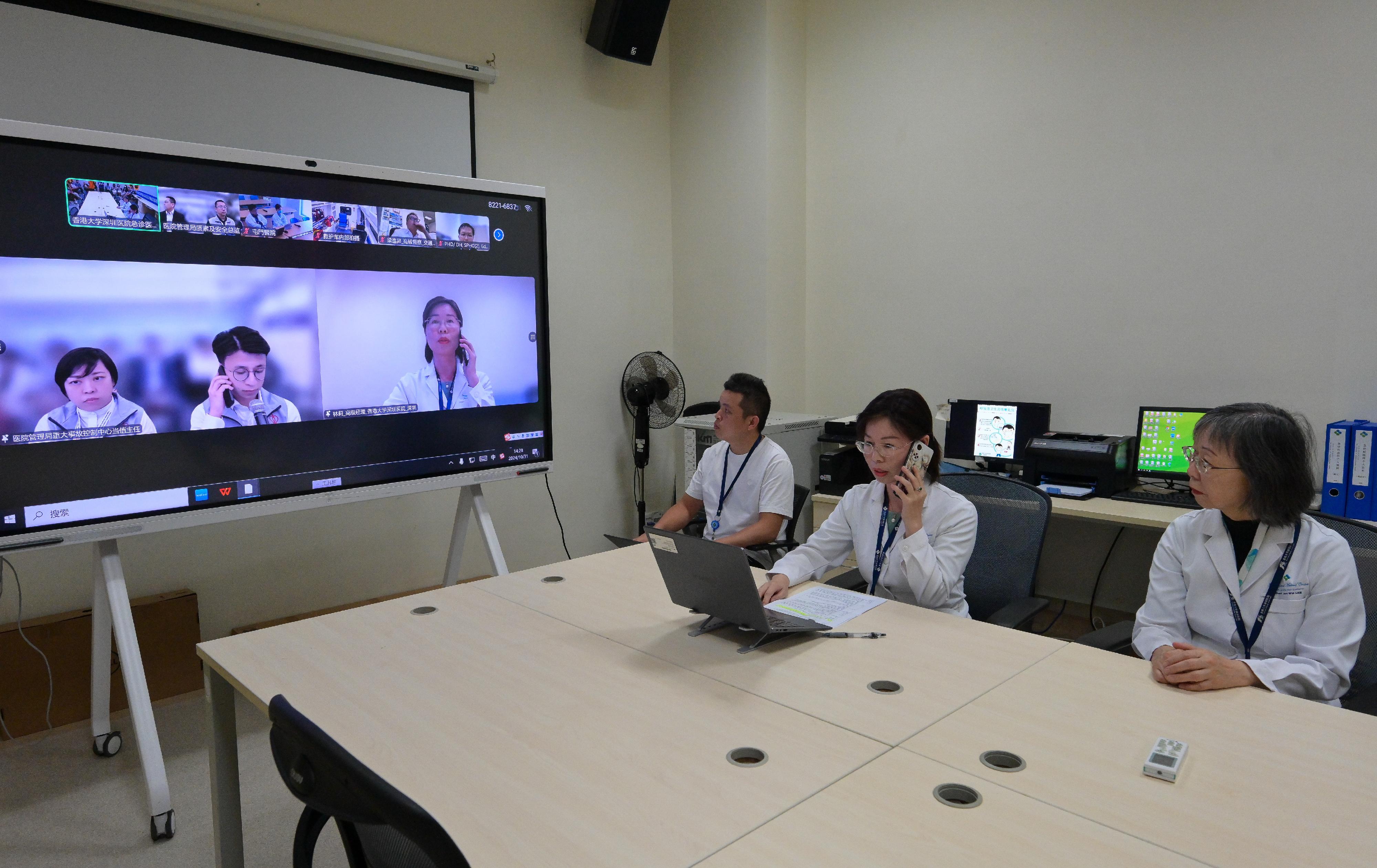 The Hong Kong Special Administrative Region Government today (October 31) conducted the second drill for the Pilot Scheme for Direct Cross-boundary Ambulance Transfer in the Greater Bay Area in collaboration with the Guangdong Provincial Government and the Shenzhen Municipal Government. Photo shows the Hong Kong and Mainland personnel discussing the overall drill arrangement and simulating the activation of the cross-boundary ambulance mechanism.
