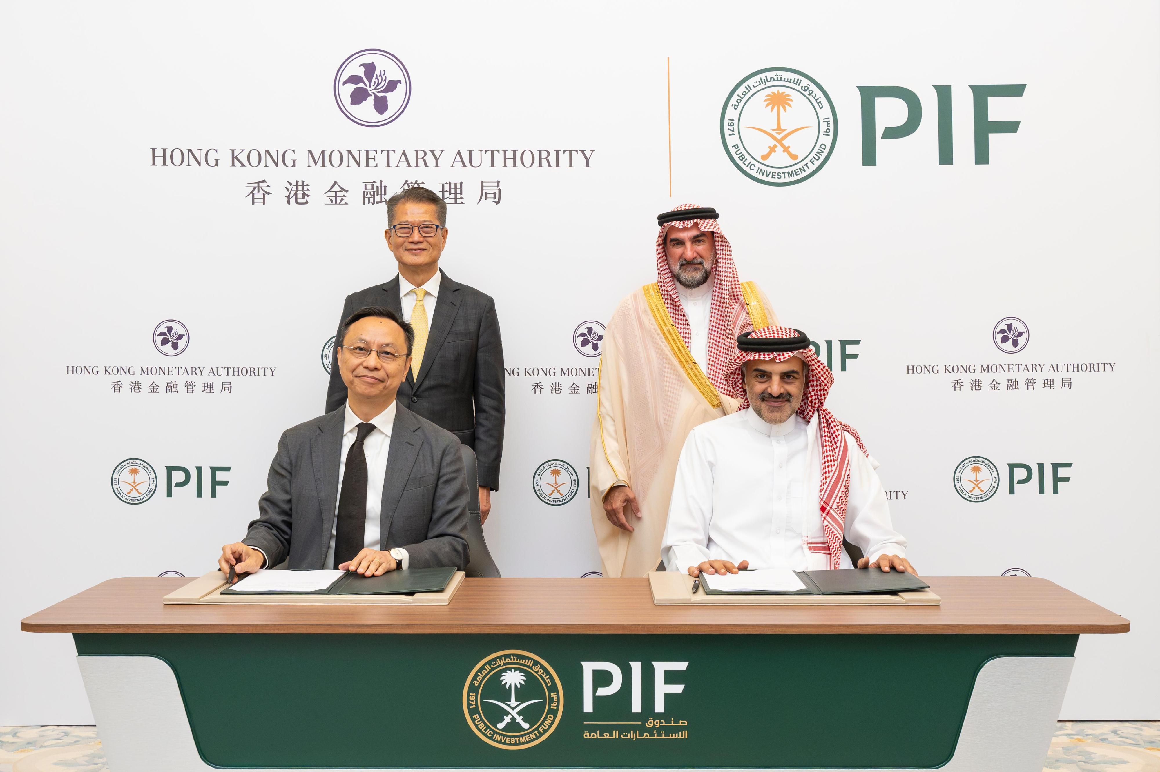 Deputy Chief Executive of the Hong Kong Monetary Authority Mr Darryl Chan (front row, left) and the Head of Local Real Estate Investments Division of the Public Investment Fund (PIF), Mr Aiman Almudaifer (front row, right), sign a memorandum of understanding for a new investment fund in the presence of the Financial Secretary of Hong Kong Speicial Administrative Region Government, Mr Paul Chan (back row, left) and the Governor of the PIF, H.E. Yasir Alrumayyan (back row, right).