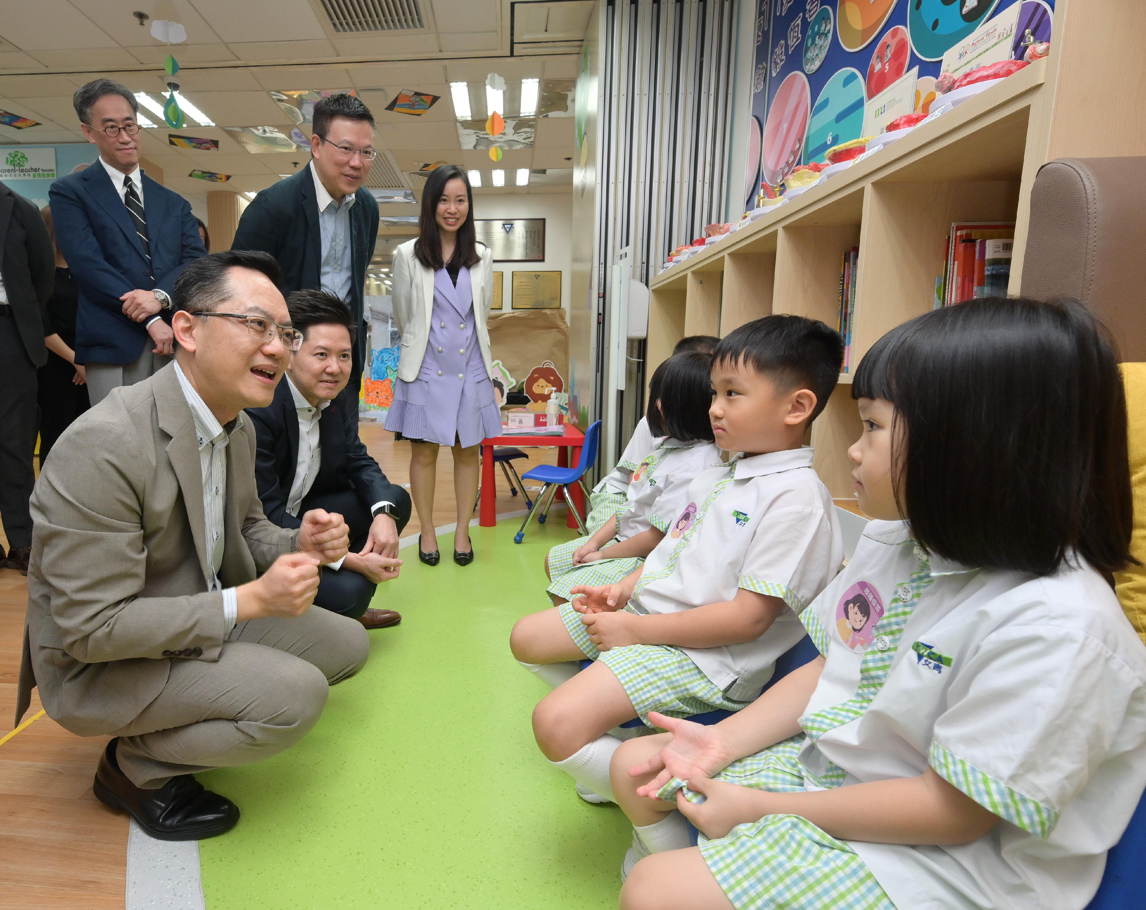 The Director of Health, Dr Ronald Lam, and the Controller of the Centre for Health Protection of the Department of Health, Dr Edwin Tsui, visited Hong Kong Young Women's Christian Association Tai Hon Fan Nursery School this morning (November 4) to view the implementation of the school outreach seasonal influenza vaccination service. Photo shows Dr Lam (first left) and Dr Tsui (second left) chatting with pupils who will receive seasonal influenza vaccinations.