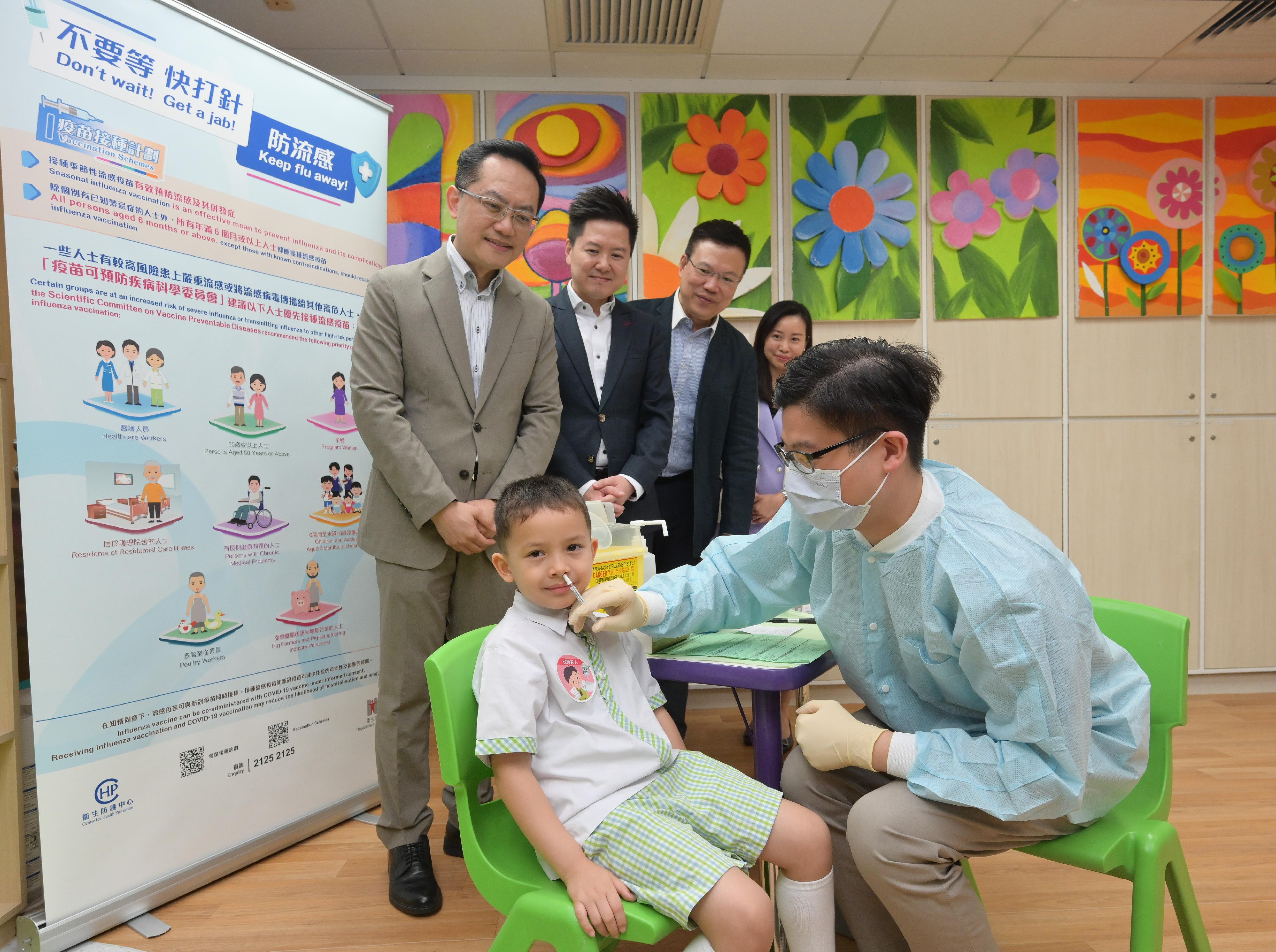 The Director of Health, Dr Ronald Lam, and the Controller of the Centre for Health Protection of the Department of Health, Dr Edwin Tsui, visited Hong Kong Young Women's Christian Association Tai Hon Fan Nursery School this morning (November 4) to view the implementation of the school outreach seasonal influenza vaccination service. Photo shows Dr Lam (back row, first left) and Dr Tsui (back row, second left) viewing a student receiving the live attenuated influenza vaccine.