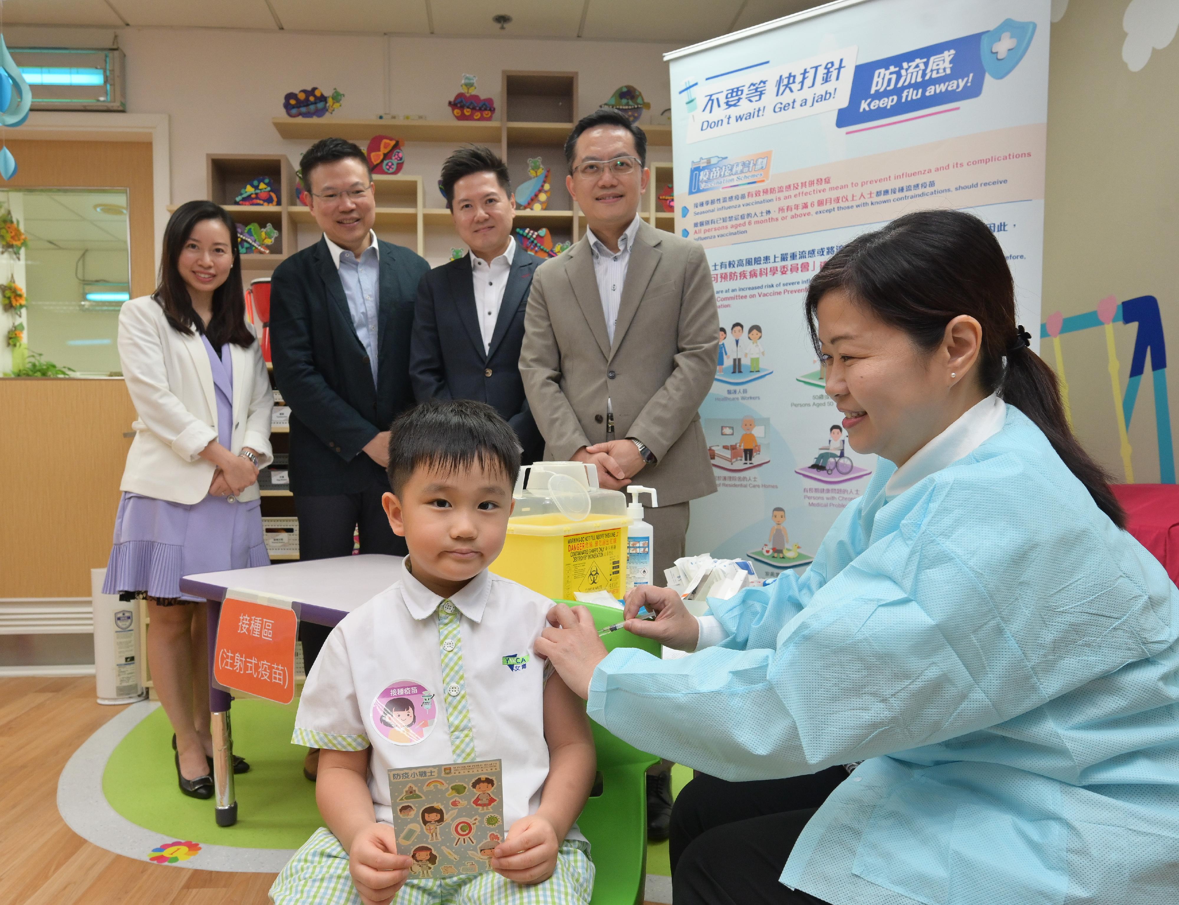 The Director of Health, Dr Ronald Lam, and the Controller of the Centre for Health Protection of the Department of Health, Dr Edwin Tsui, visited Hong Kong Young Women's Christian Association Tai Hon Fan Nursery School this morning (November 4) to view the implementation of the school outreach seasonal influenza vaccination service. Photo shows Dr Lam (back row, first right) and Dr Tsui (back row, second right) viewing a student receiving the injectable inactivated influenza vaccine.