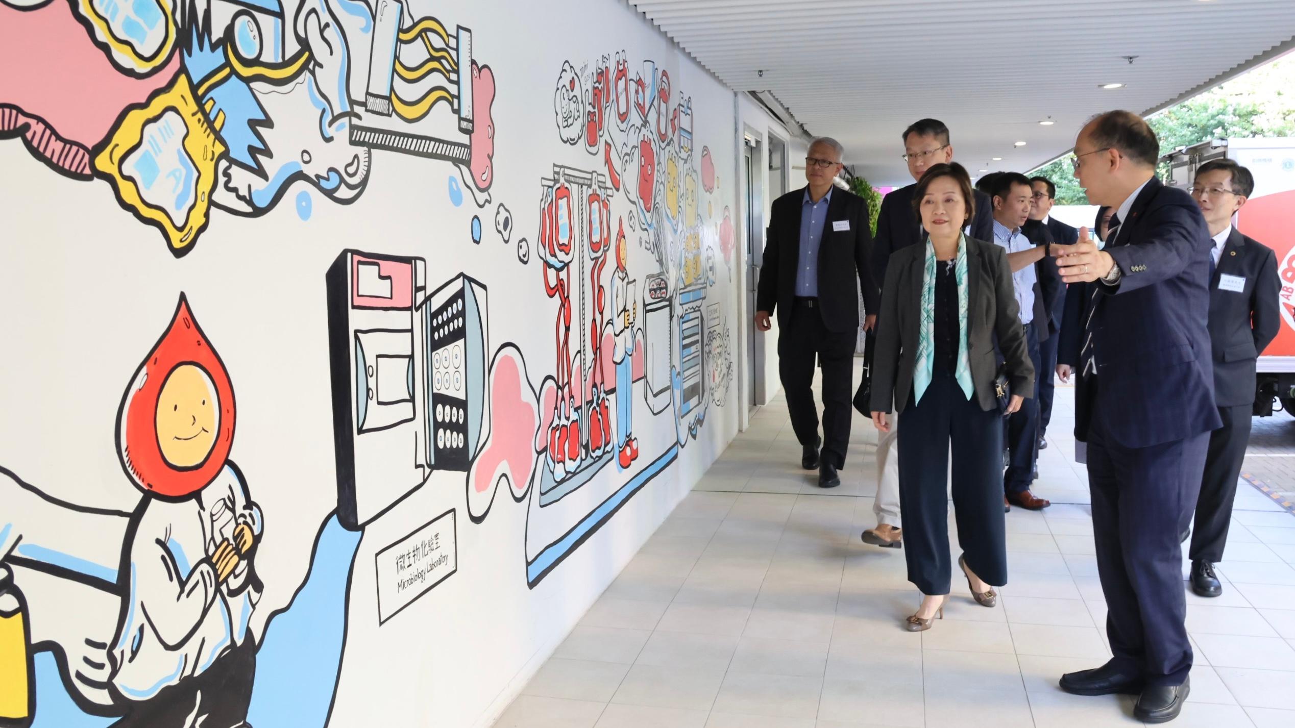 The Hong Kong Red Cross Blood Transfusion Service (BTS) invited the Secretary for Education, Dr Choi Yuk-lin, and the delegation of associations of secondary school heads to the BTS Headquarters today (November 7). Photo shows the Chief Executive and Medical Director of the BTS, Dr Lee Cheuk-kwong, introducing the education mural wall.