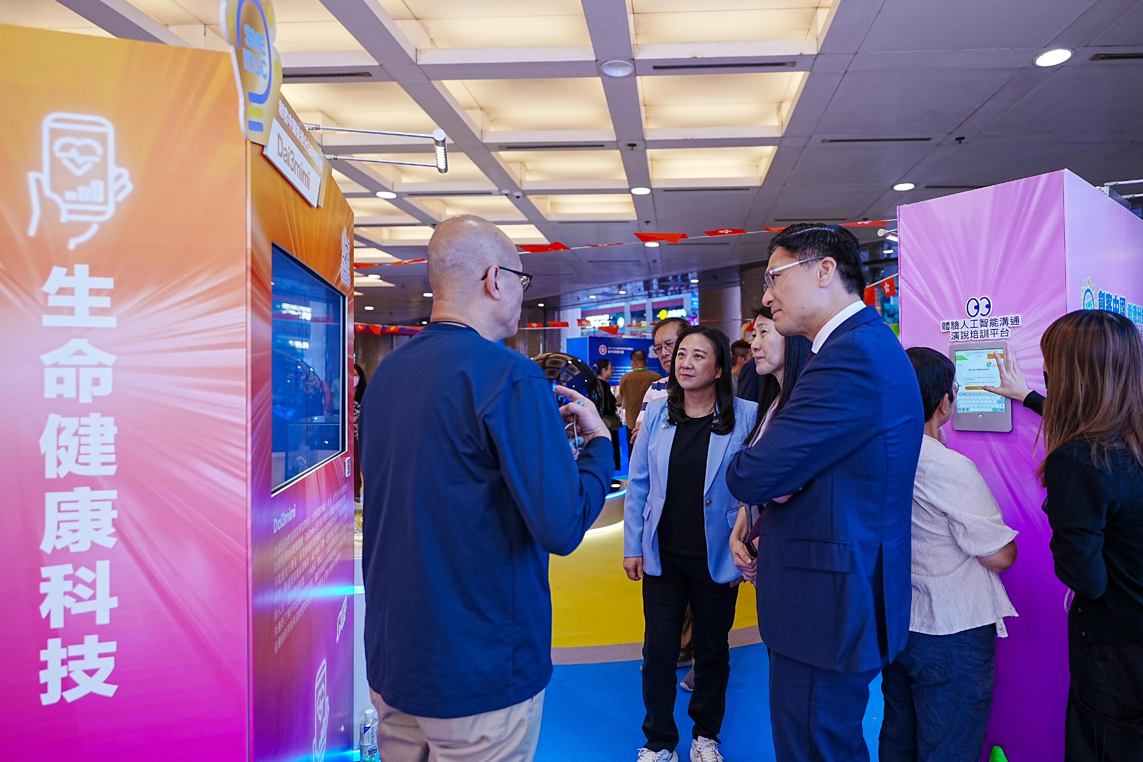 Digital Policy Office is holding the Exhibition of Winning Entries of the "Maker in China" SME Innovation and Entrepreneurship Global Contest Hong Kong Chapter for two consecutive days starting today (November 8). Picture shows the Chairman of the Panel on Information Technology and Broadcasting, Legislative Council, Dr Elizabeth Quat (centre), and member Mr Duncan Chiu (front row, first right), listening to briefing by the winning team at an exhibition booth.