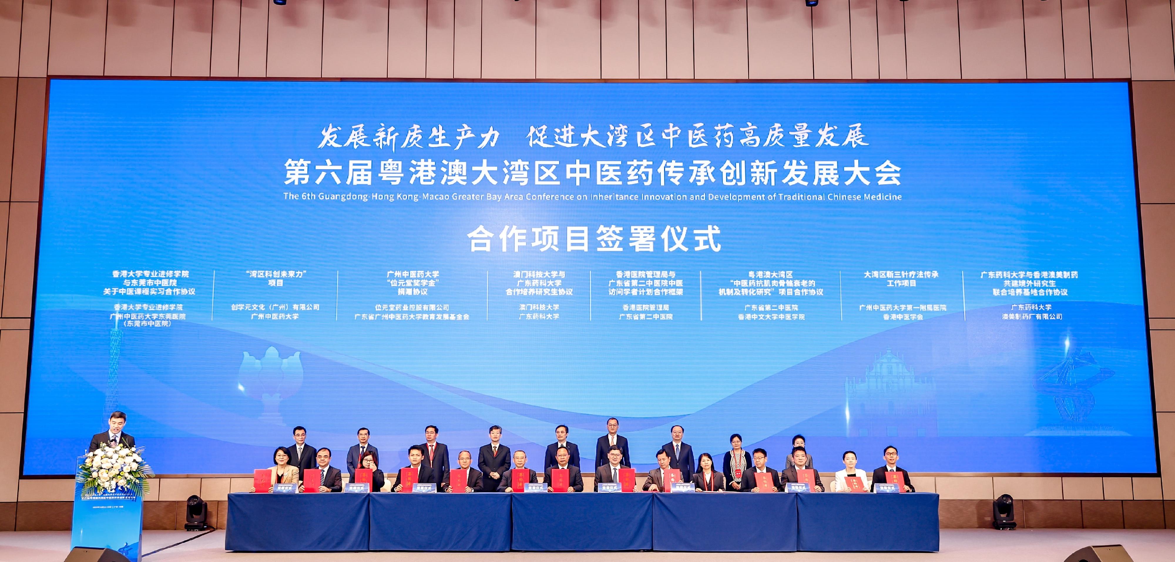 The Secretary for Health, Professor Lo Chung-mau, led a delegation to attend the 6th Guangdong-Hong Kong-Macao Greater Bay Area Conference on Inheritance, Innovation and Development of Traditional Chinese Medicine in Dongguan today (November 14). Photo shows Professor Lo (back row, fourth right) and Vice Commissioner of the National Administration of Traditional Chinese Medicine Professor Huang Luqi (back row, fifth right) witnessing at the conference the signing of various agreements on multiple Guangdong-Hong Kong-Macao Greater Bay Area (GBA) Chinese medicine (CM) co-operation projects, among which the Chief Executive of the Hospital Authority (HA), Dr Tony Ko (front row, seventh right), signs the Co-operation Framework on GBA CM Visiting Scholars Programme between the HA and Guangdong Second Traditional Chinese Medicine Hospital with a view to strengthening the professional clinical exchange and promoting the development of integrated Chinese-Western medicine services.