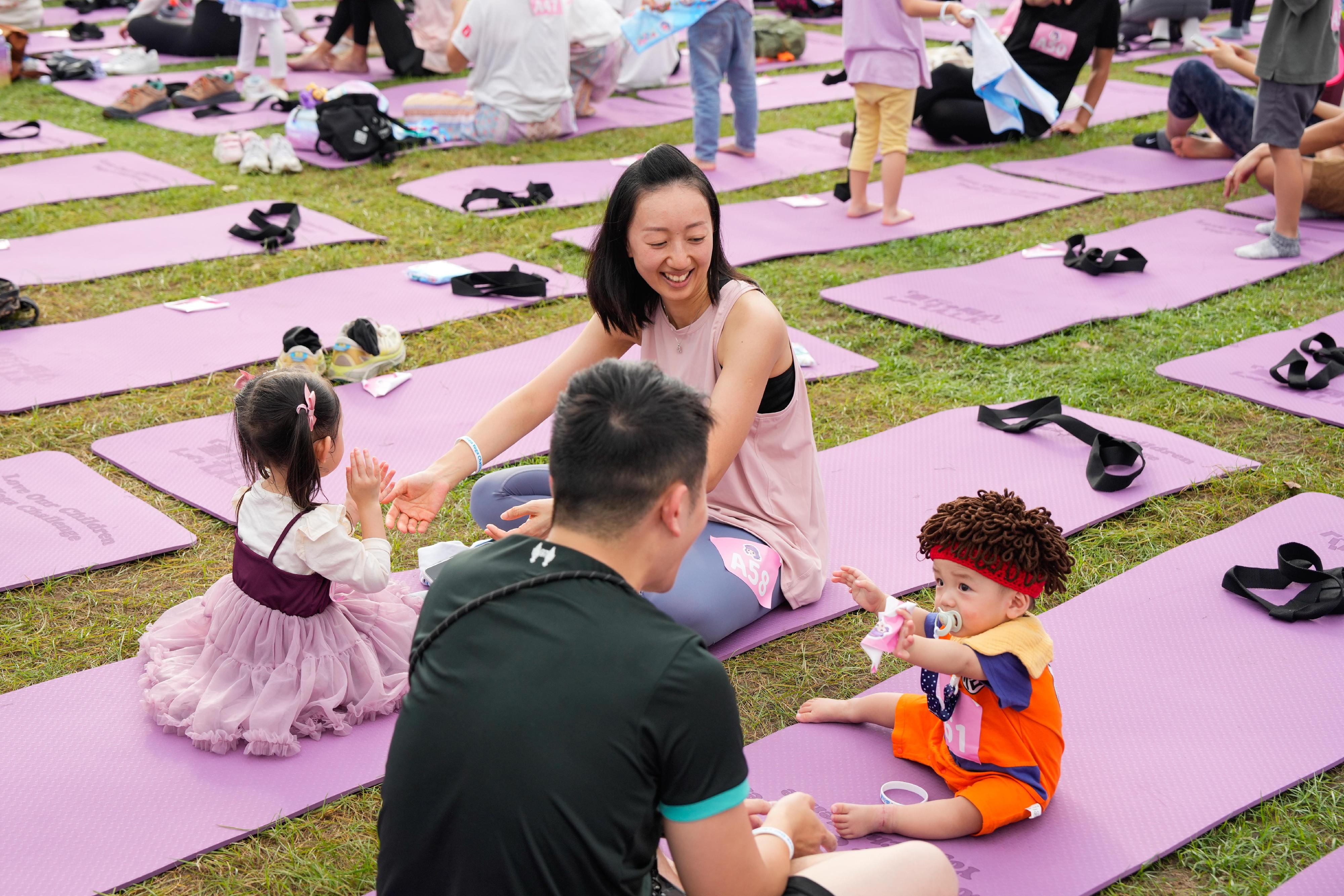 參加者在開幕活動「Love Our Children Yoga Challenge」進行雙人瑜伽挑戰，並創下一項親子瑜伽的世界紀錄。