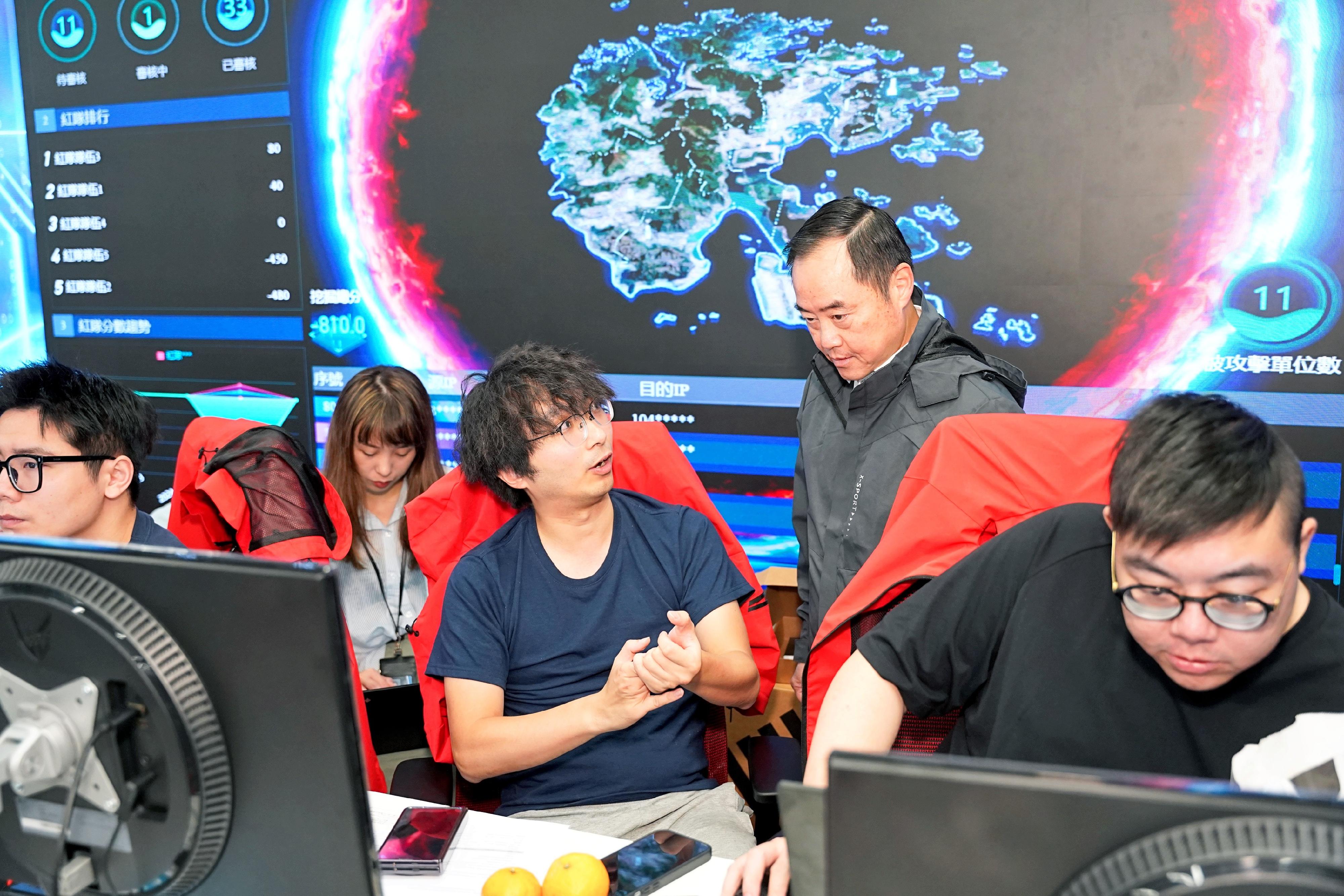 During the "Hong Kong Cybersecurity Attack and Defence Drill 2024", the Commissioner for Digital Policy, Mr Tony Wong, (second right) visited the venue to engage in exchanges with the participating teams. 