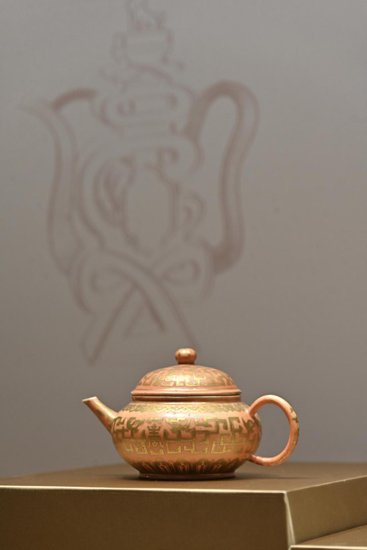 To celebrate the 40th anniversary of the Flagstaff House Museum of Tea Ware, the thematic exhibition "Rendezvous with Tea" will be opened from November 24 with a theme of auspicious and profound blessings. Photo shows a teapot of a flattened globular shape with an archaic pattern in gilt on a coral red ground, from the Daoguang period of the Qing dynasty.