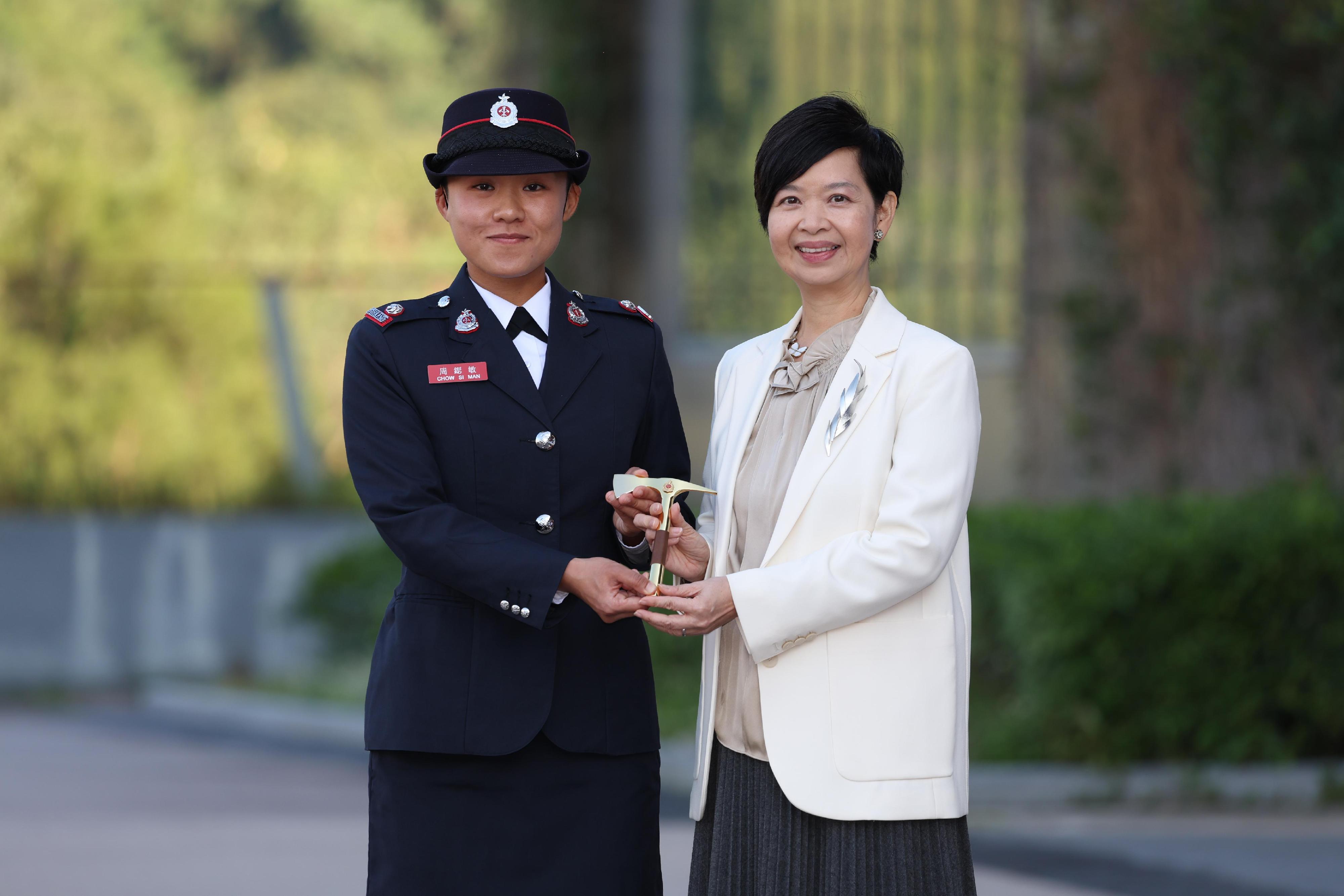 The Secretary for Housing, Ms Winnie Ho, reviewed the Fire Services passing-out parade at the Fire and Ambulance Services Academy today (November 22). Photo shows Ms Ho (right) presenting the Best Recruit Station Officer award to a graduate.