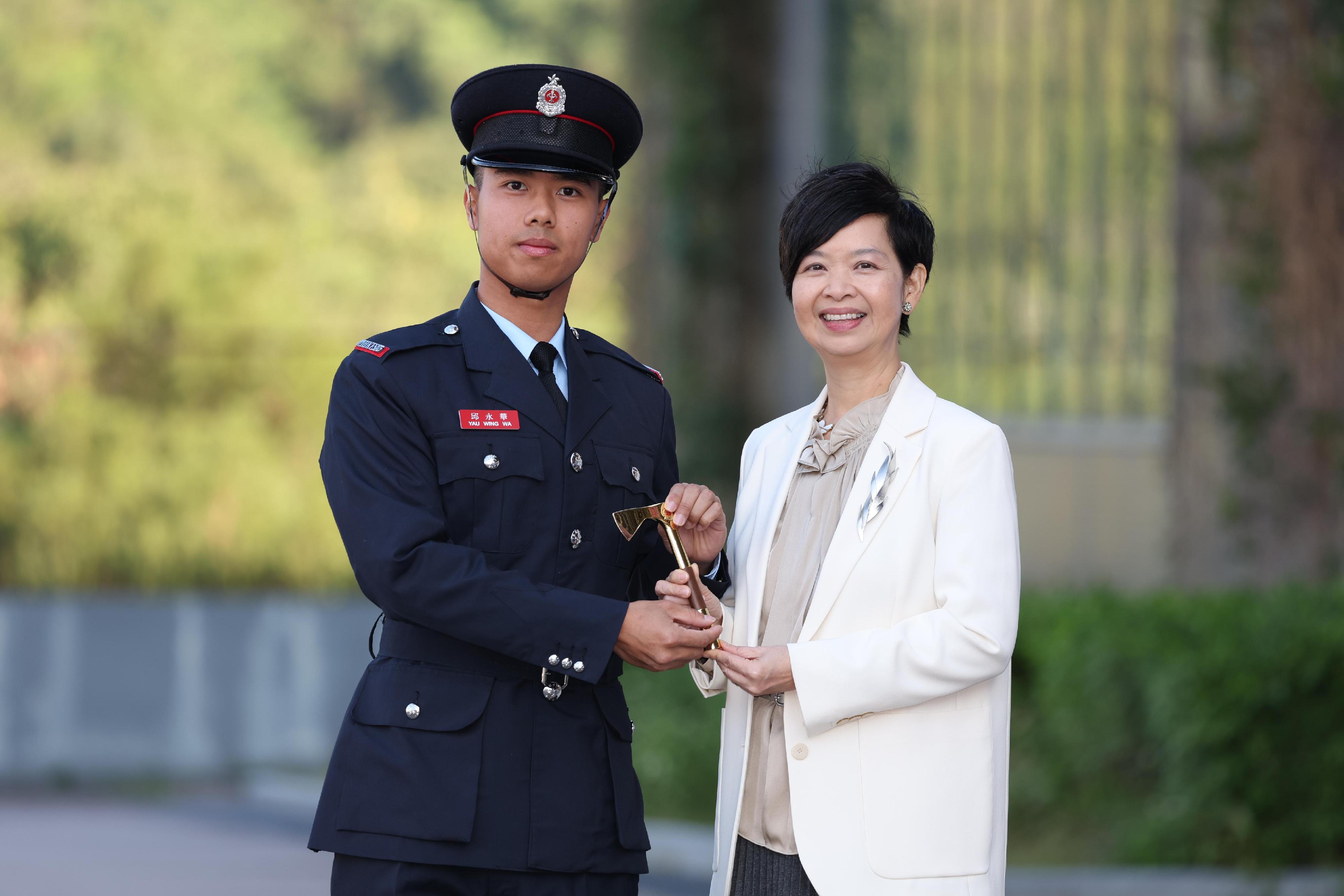 The Secretary for Housing, Ms Winnie Ho, reviewed the Fire Services passing-out parade at the Fire and Ambulance Services Academy today (November 22). Photo shows Ms Ho (right) presenting the Best Recruit Fireman award to a graduate.