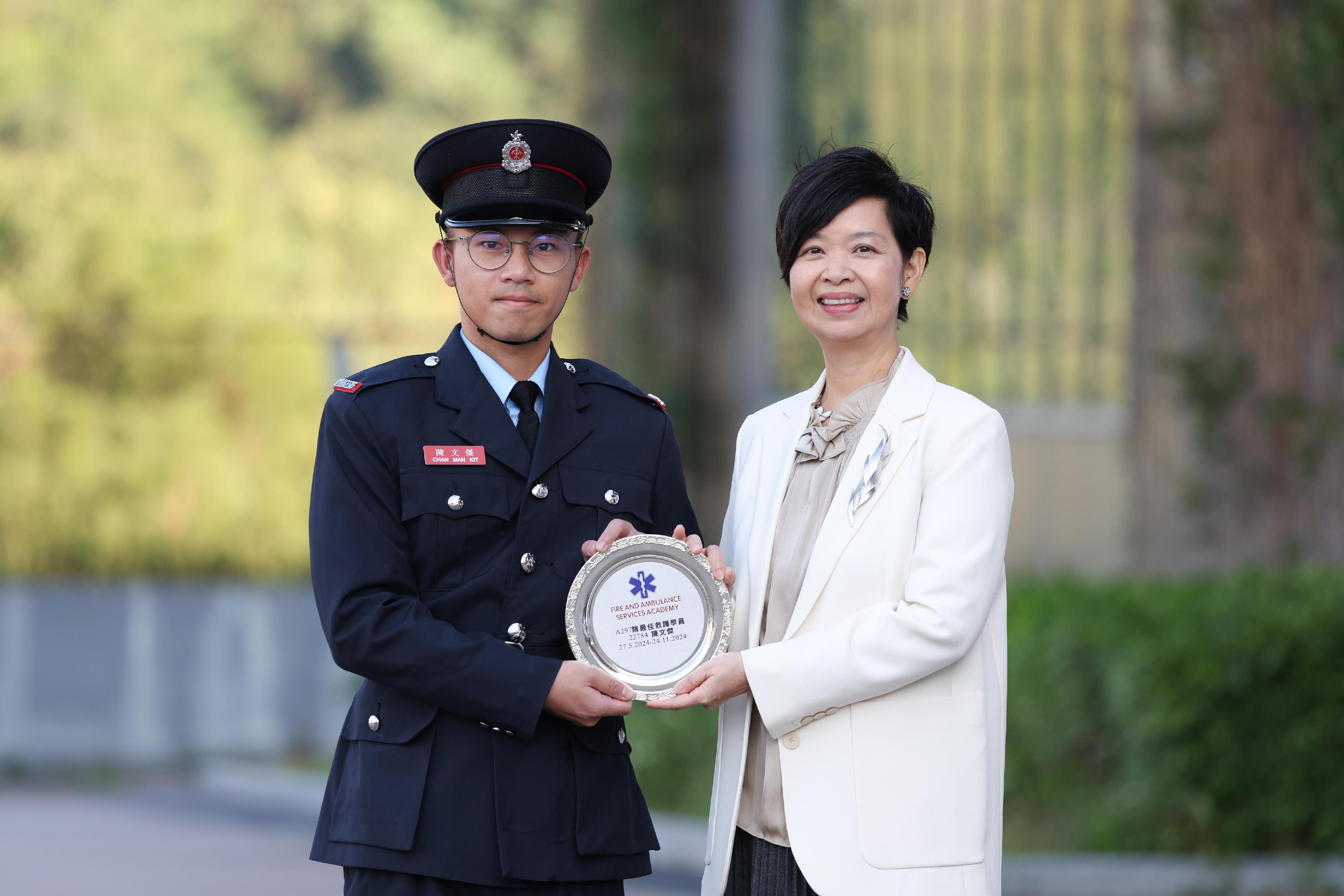 The Secretary for Housing, Ms Winnie Ho, reviewed the Fire Services passing-out parade at the Fire and Ambulance Services Academy today (November 22). Photo shows Ms Ho (right) presenting the Best Recruit Ambulanceman award to a graduate.