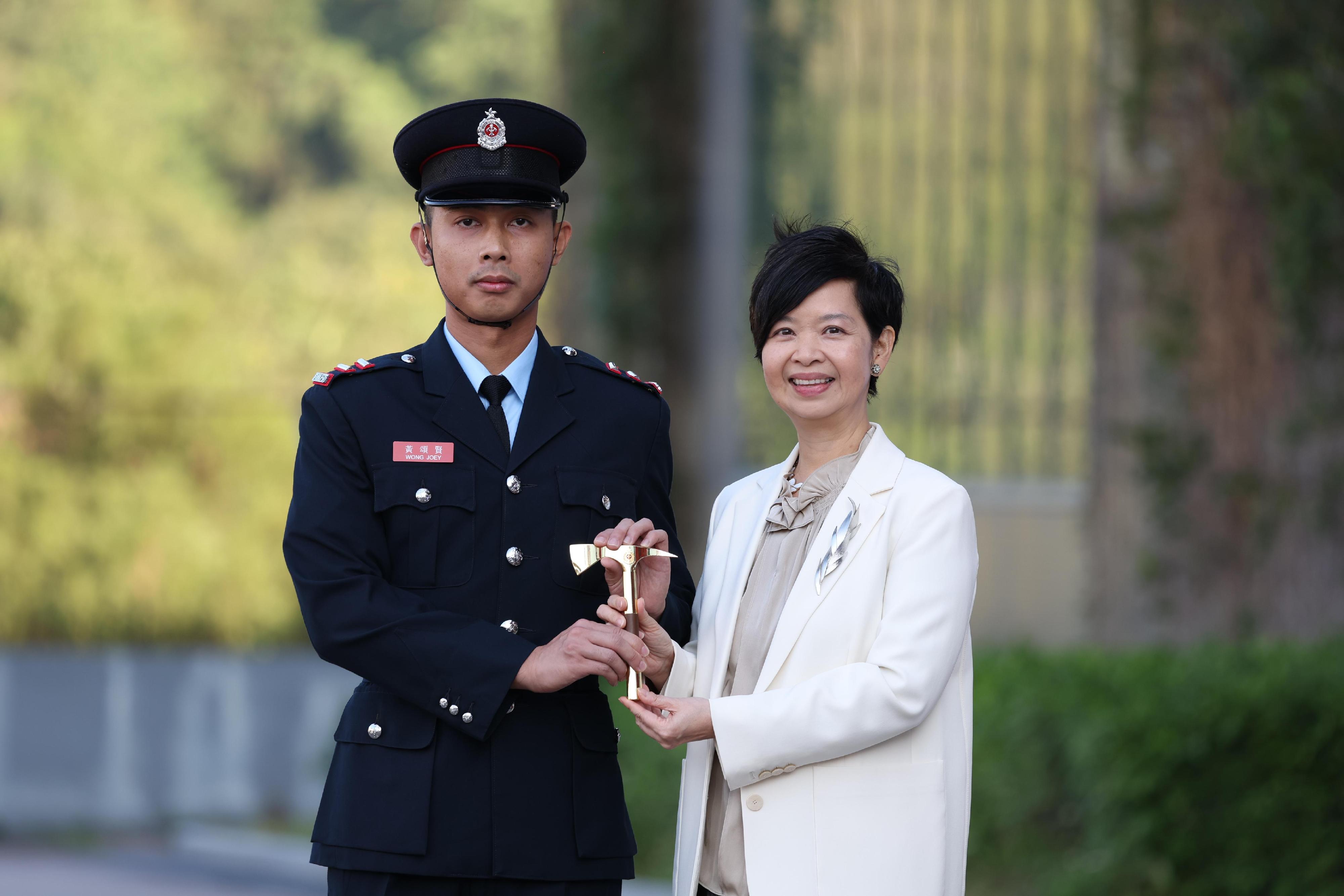 The Secretary for Housing, Ms Winnie Ho, reviewed the Fire Services passing-out parade at the Fire and Ambulance Services Academy today (November 22). Photo shows Ms Ho (right) presenting the Best Recruit Senior Fireman (Control) award to a graduate.